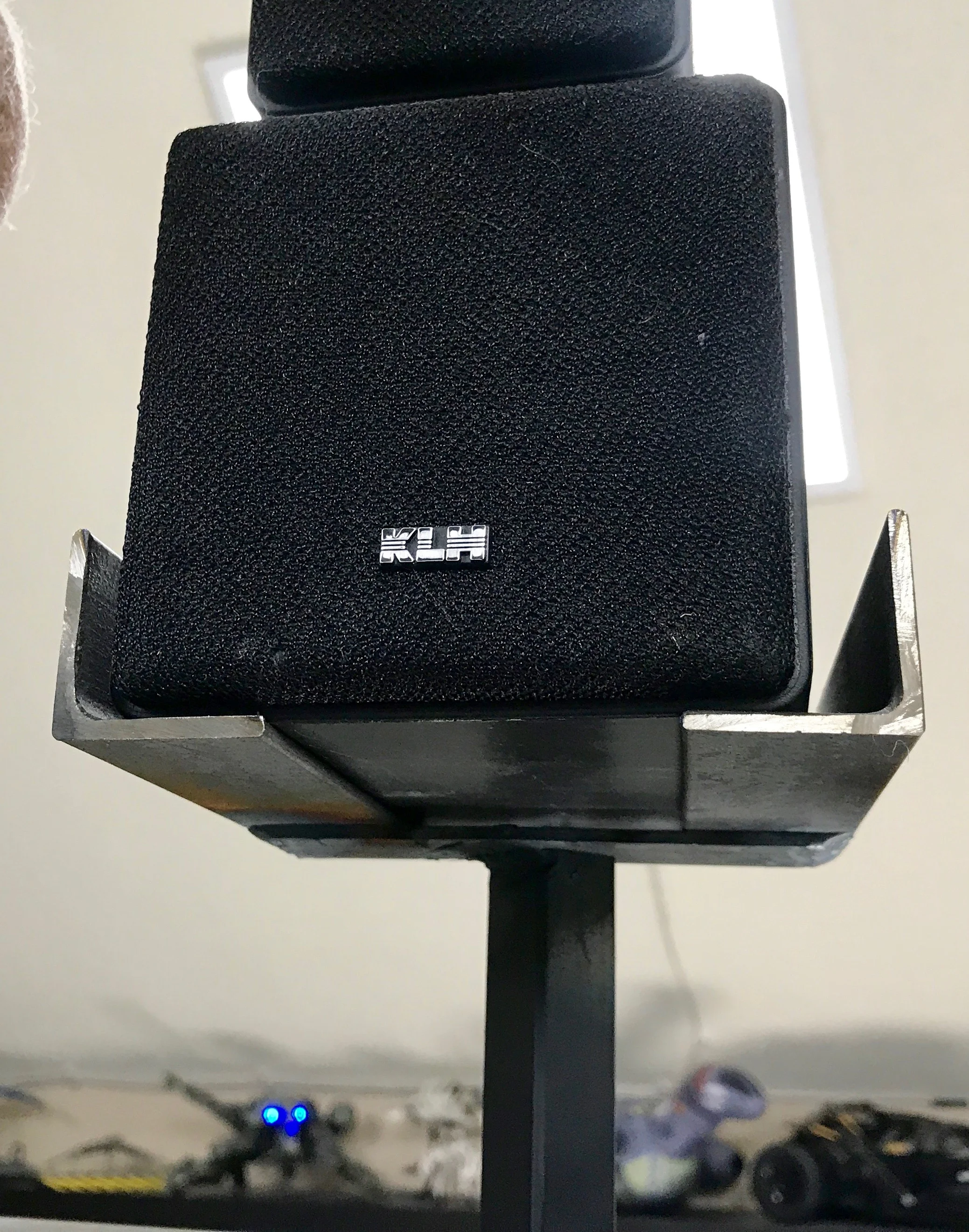 The underside of one of the speaker stands, showing the cross bar that the L pieces are welded to.