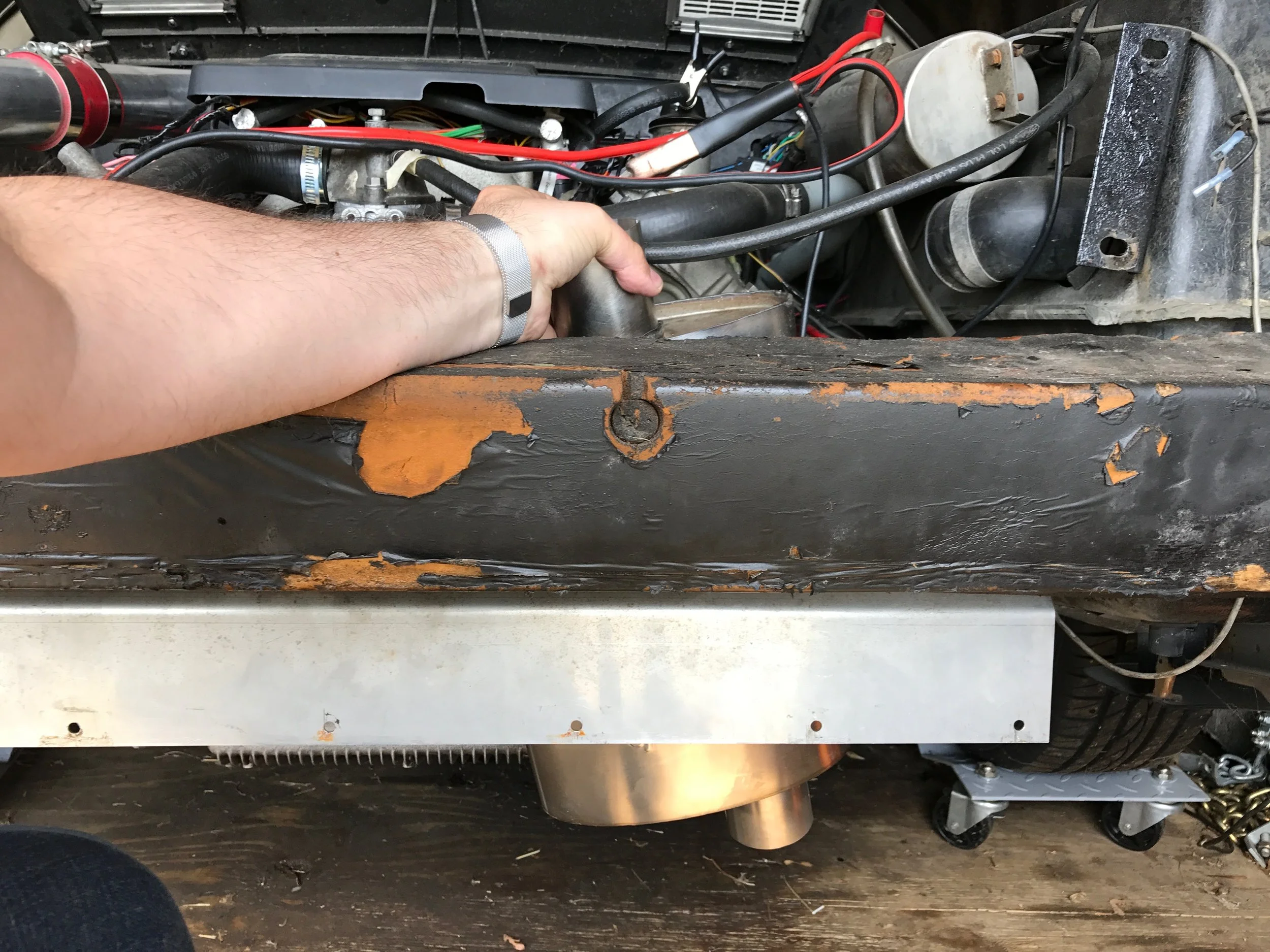 A test fit showing how badly my original muffler plan worked. The muffler needed to be mounted at about a 45 degree angle, and was too big to fit. The tail pipes need to come out next to the metal shield under the bumper.