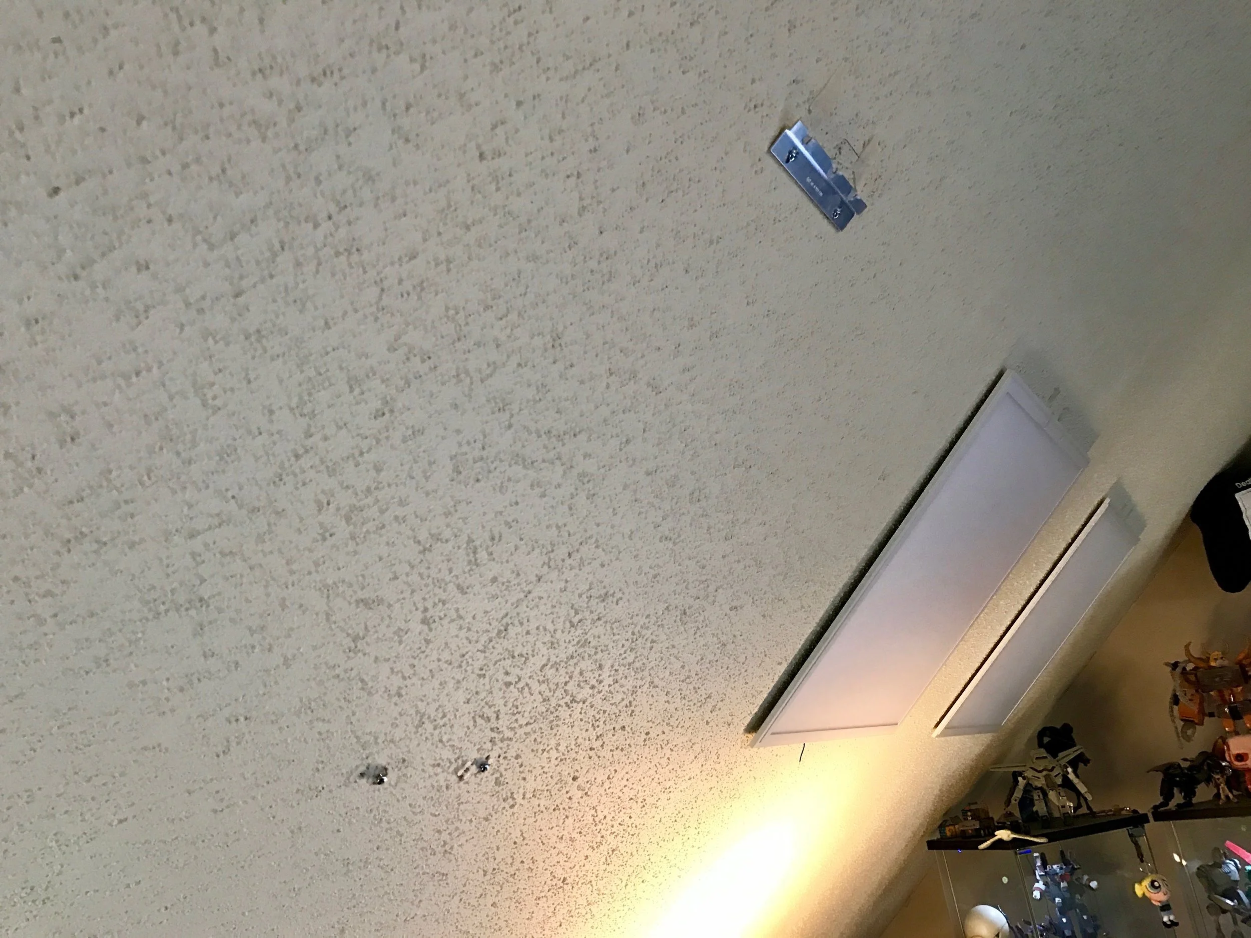 A French cleat with two notches cut out of it sits at the opt of the light, which the longer screws slip into. The Z-clips slip over the two screws at the bottom.