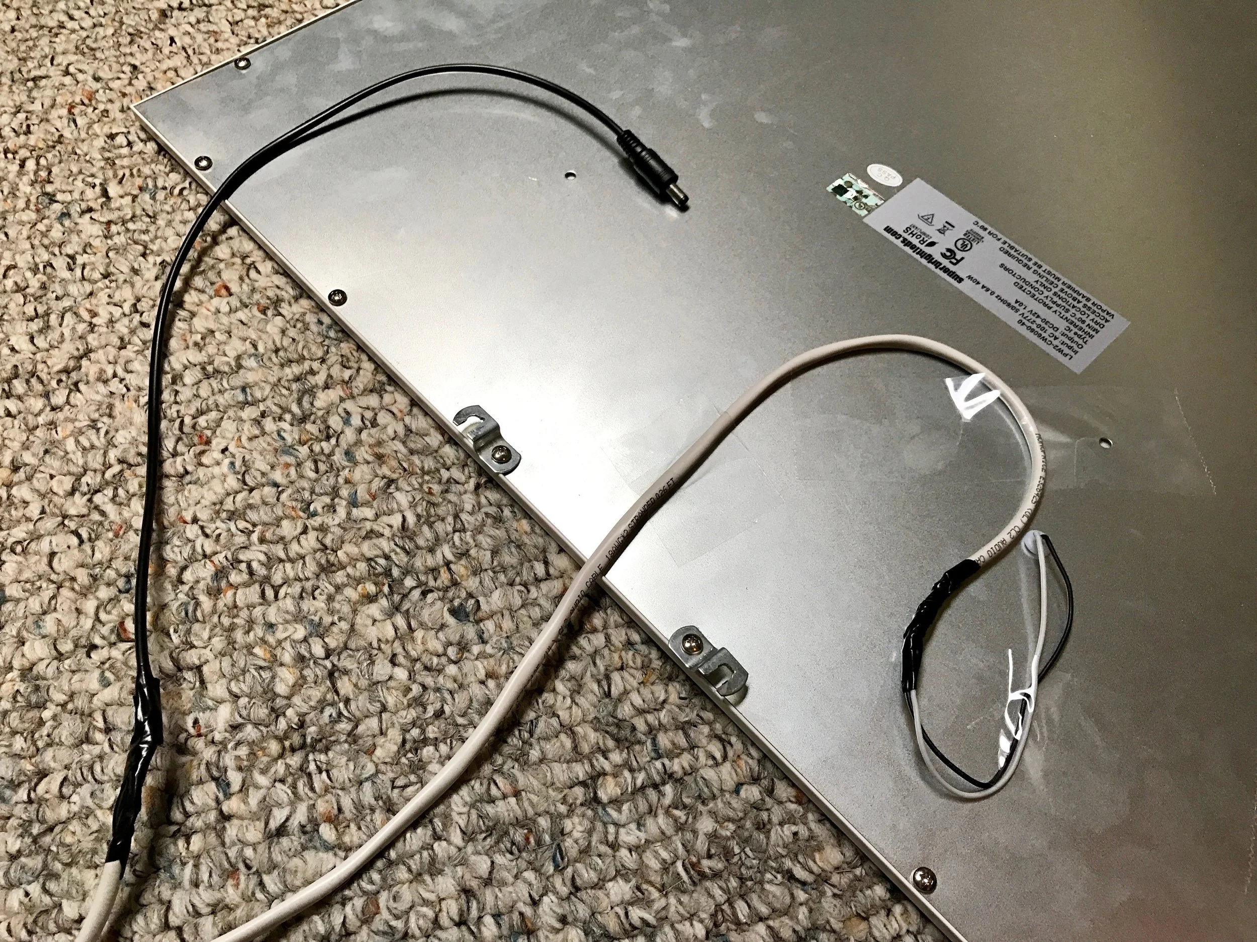 18 gauge wire soldered to the LED panel, eventually ending in a DC power connector pigtail. The cable is taped to the back of the light in a loop to act as a simple strain relief.