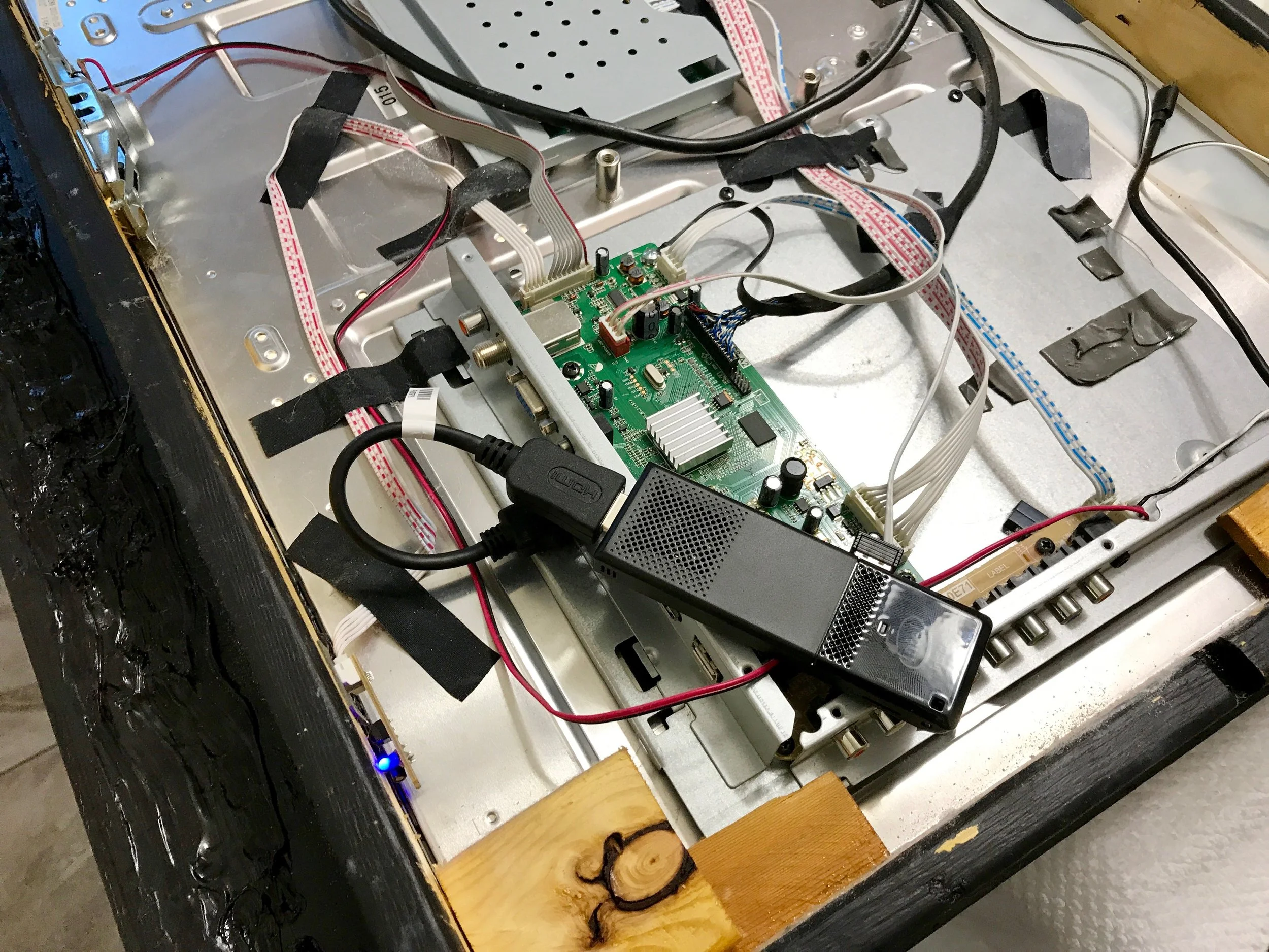 The Intel Compute Stick mounted on the frame of the TV, to provide a bit of cooling and maybe reduce some of the wifi signal attenuation.