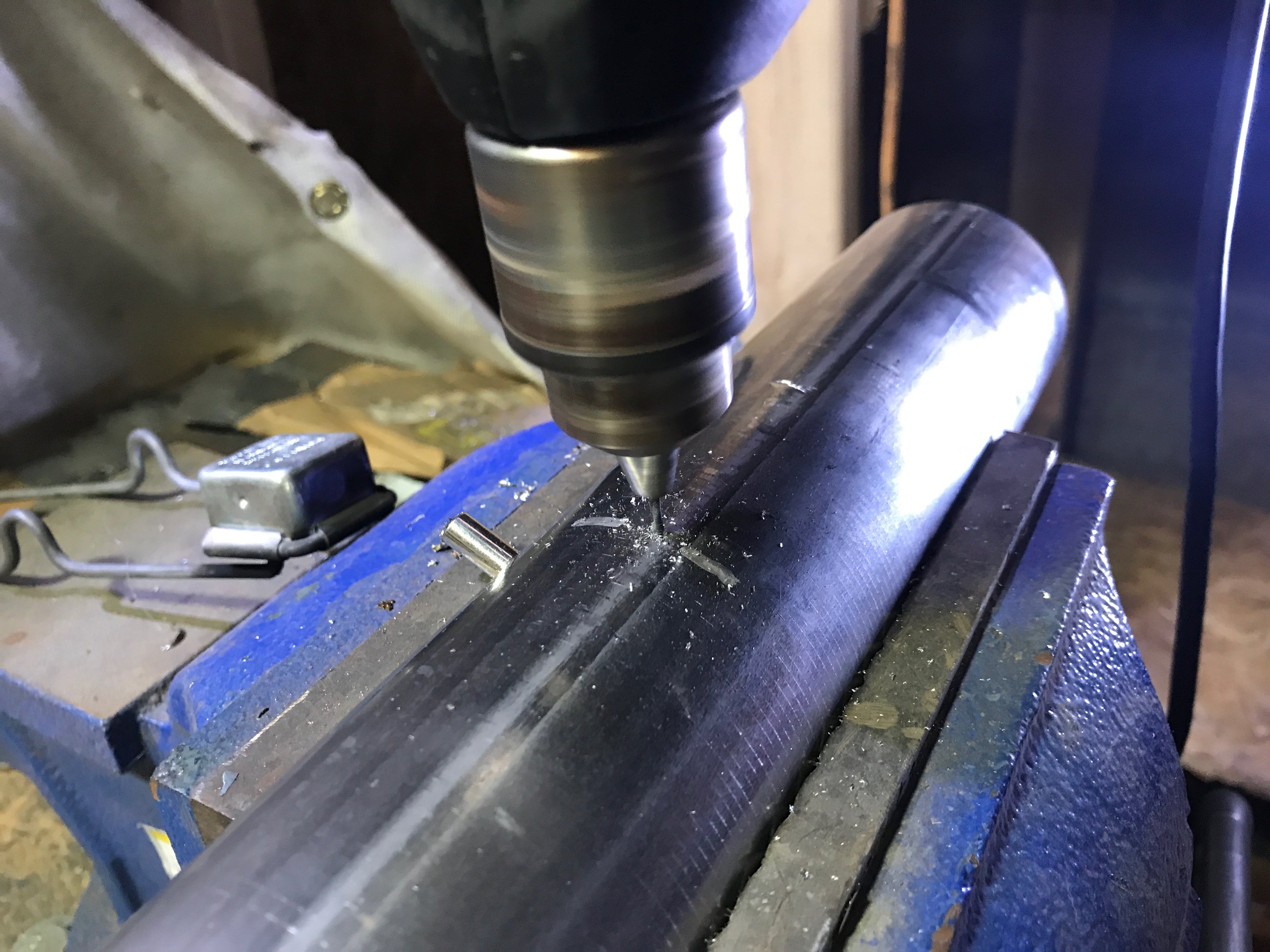 Drilling a hole through both the pipe and the silencer at the same time.