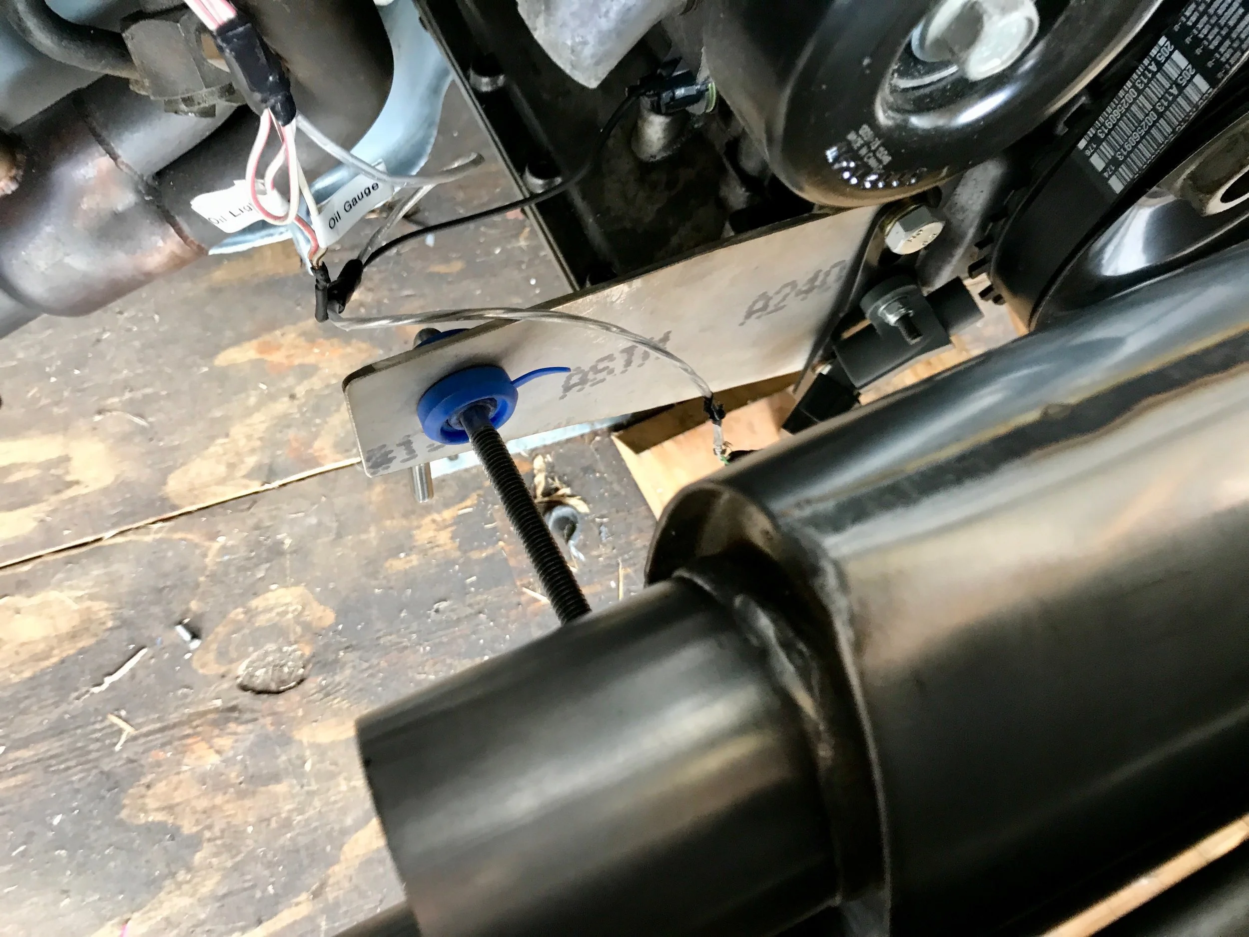 The fabricated driver side mount and its silicone insert. The rod goes to a hanger clamped to the bottom pipe of the muffler.