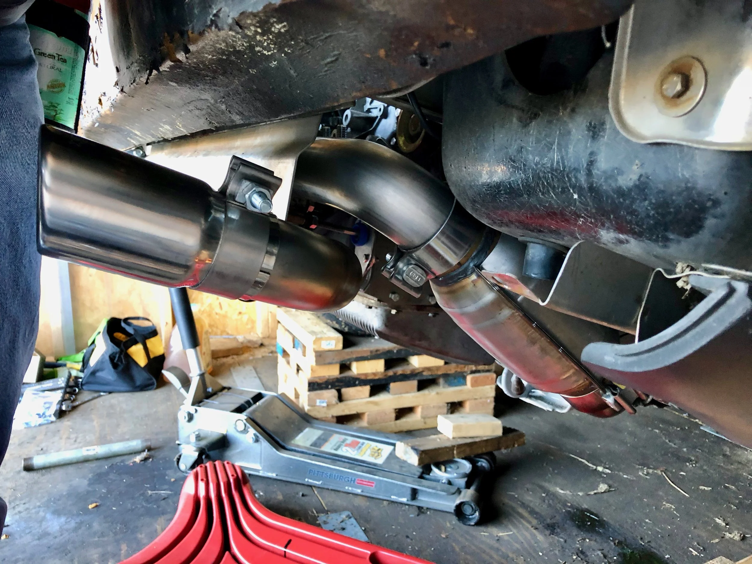 The passenger side exhaust tip, whose pipe comes out of the bottom of the muffler.
