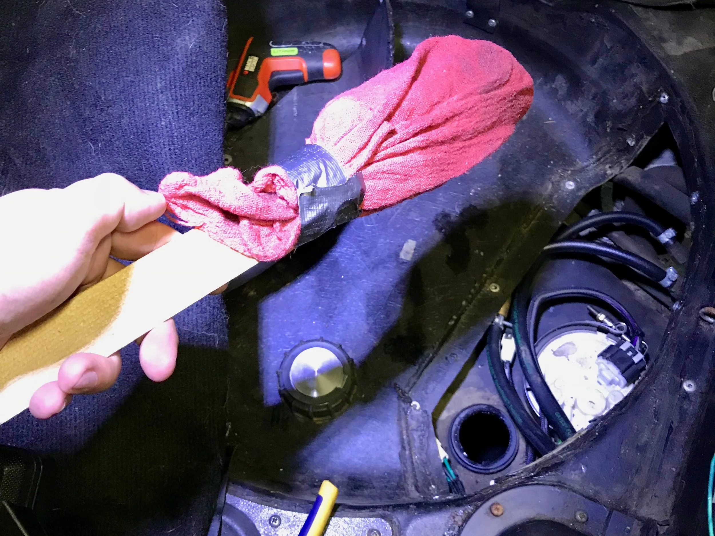The rag-on-a-stick I used to wipe out the tank. The hole where the fuel sender cap normally resides can be seen in the lower right, next to the fuel pump.