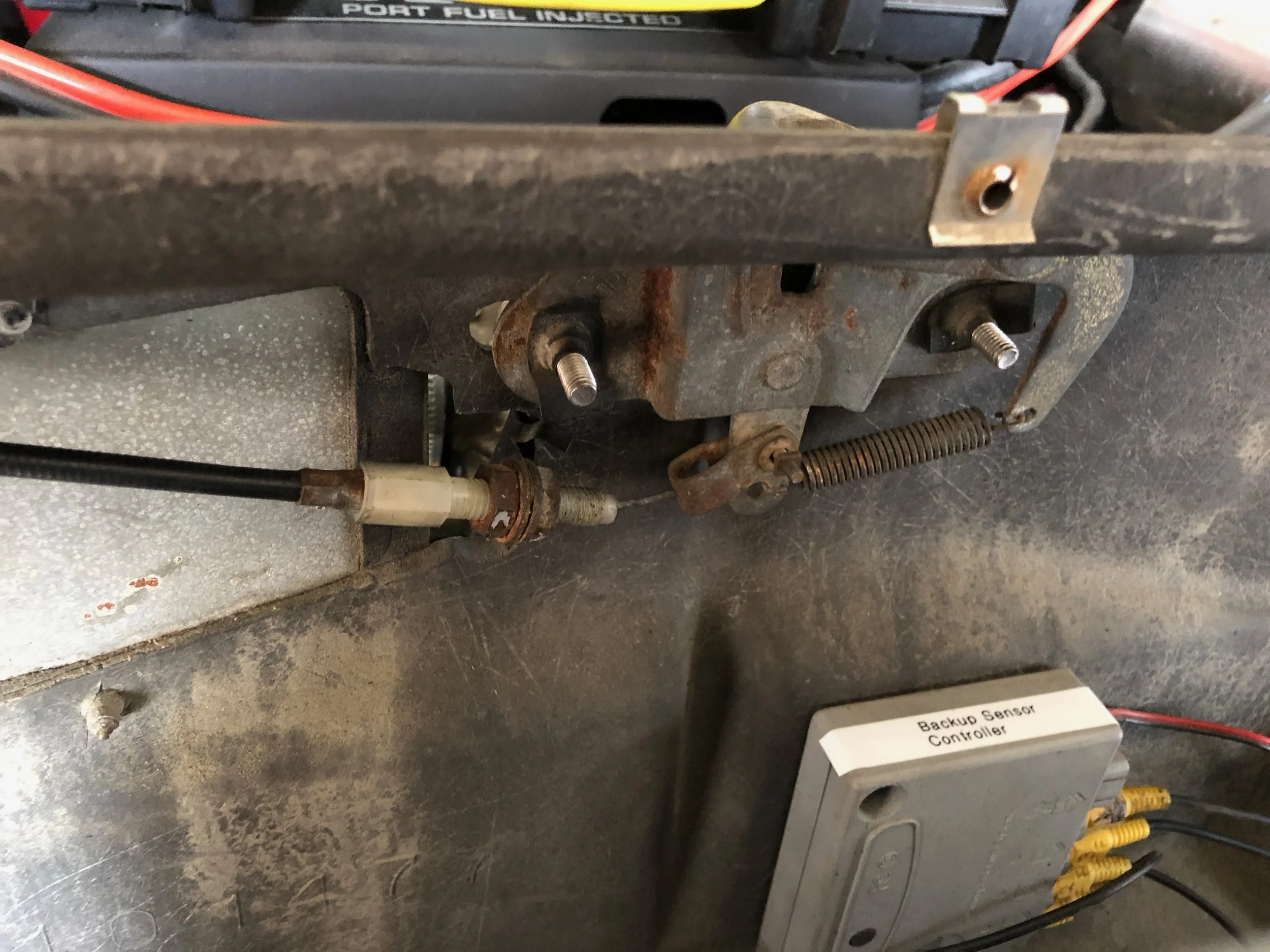The final installation of the engine latch, with the cable connected in the proper orientation.