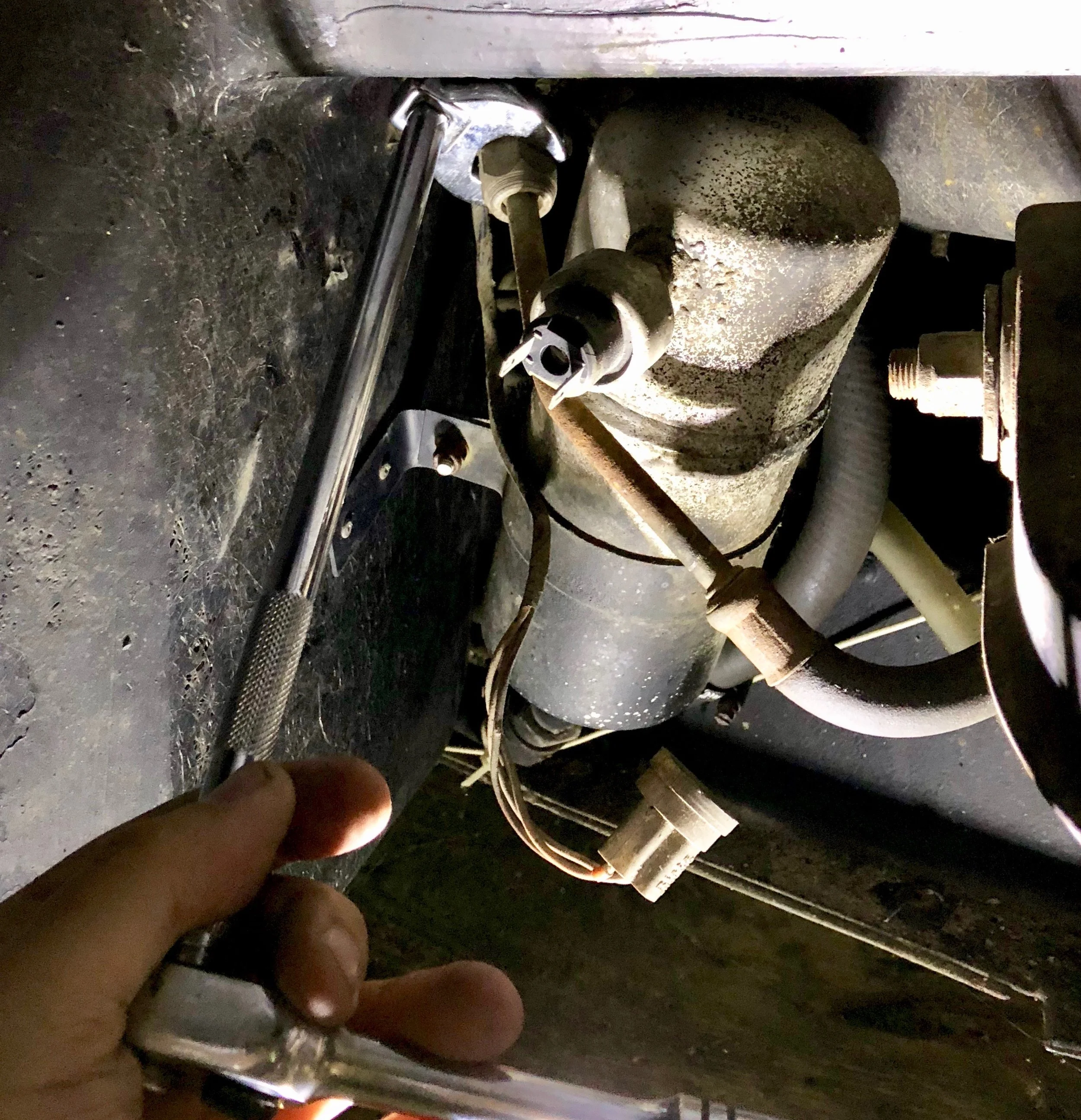 Disconnecting the line from the evaporator to the condenser with a 22mm crows foot wrench.