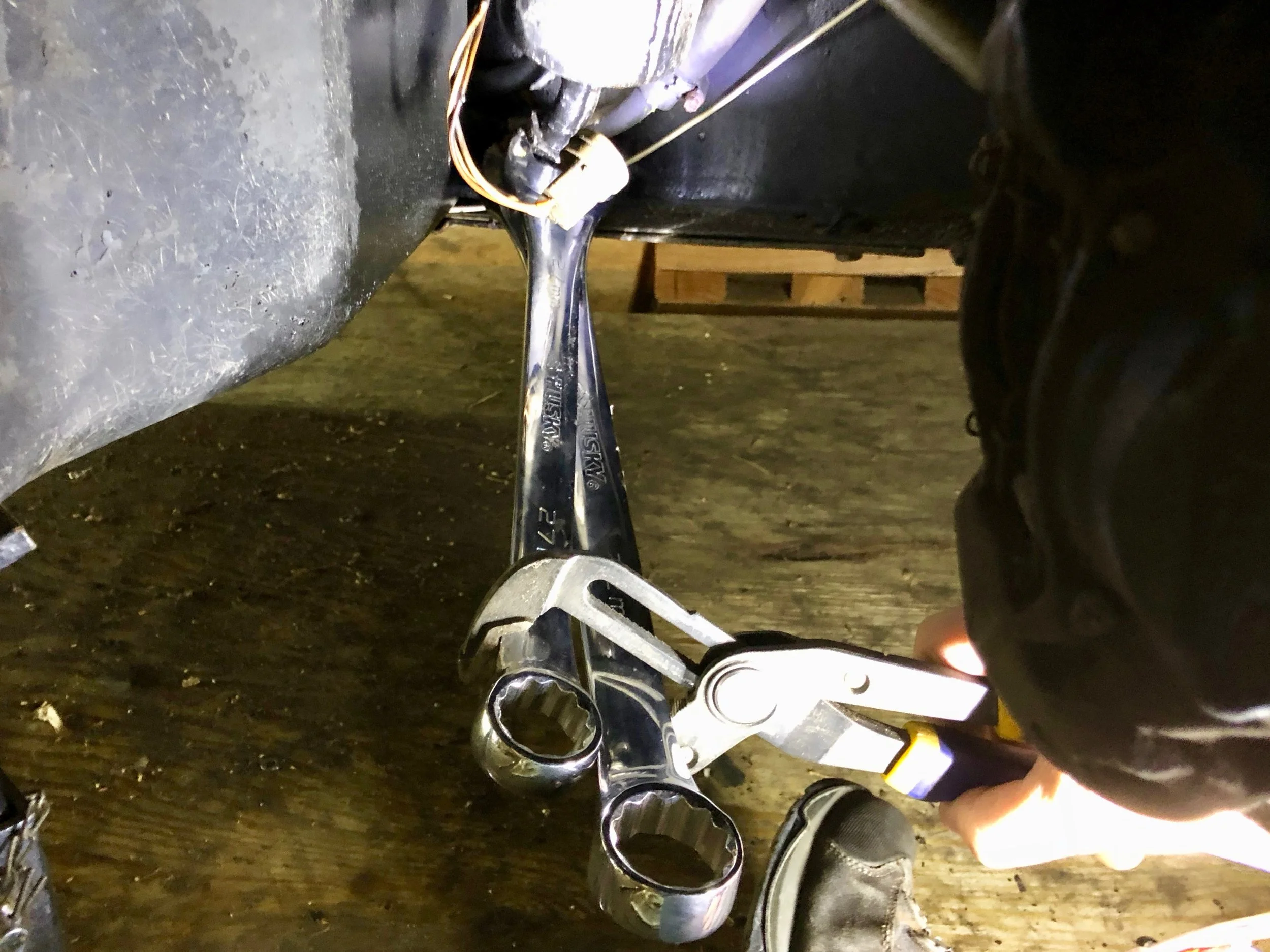 Using two wrenches and an adjustable wrench to get enough leverage to separate the lower hose.