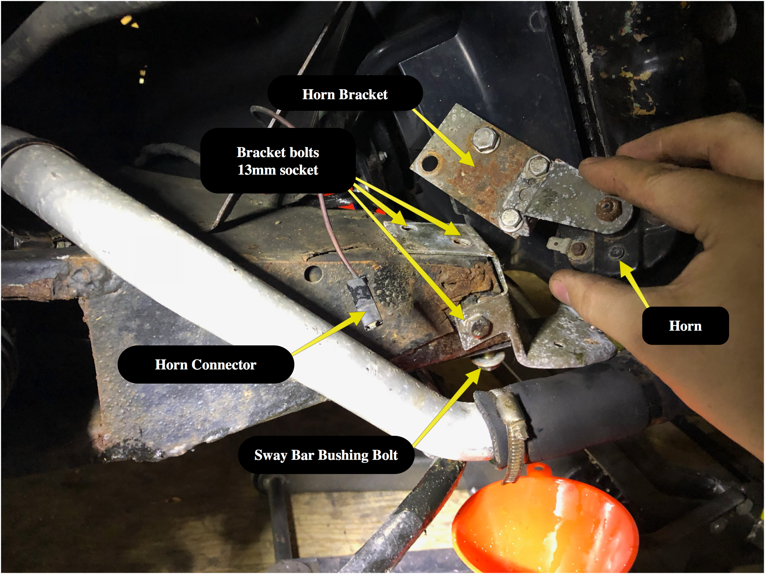 The bolts that are removed for the radiator bracket. The angled brace can be seen along the top and left of the photo as well. The large pipe in the foreground is the radiator hose.