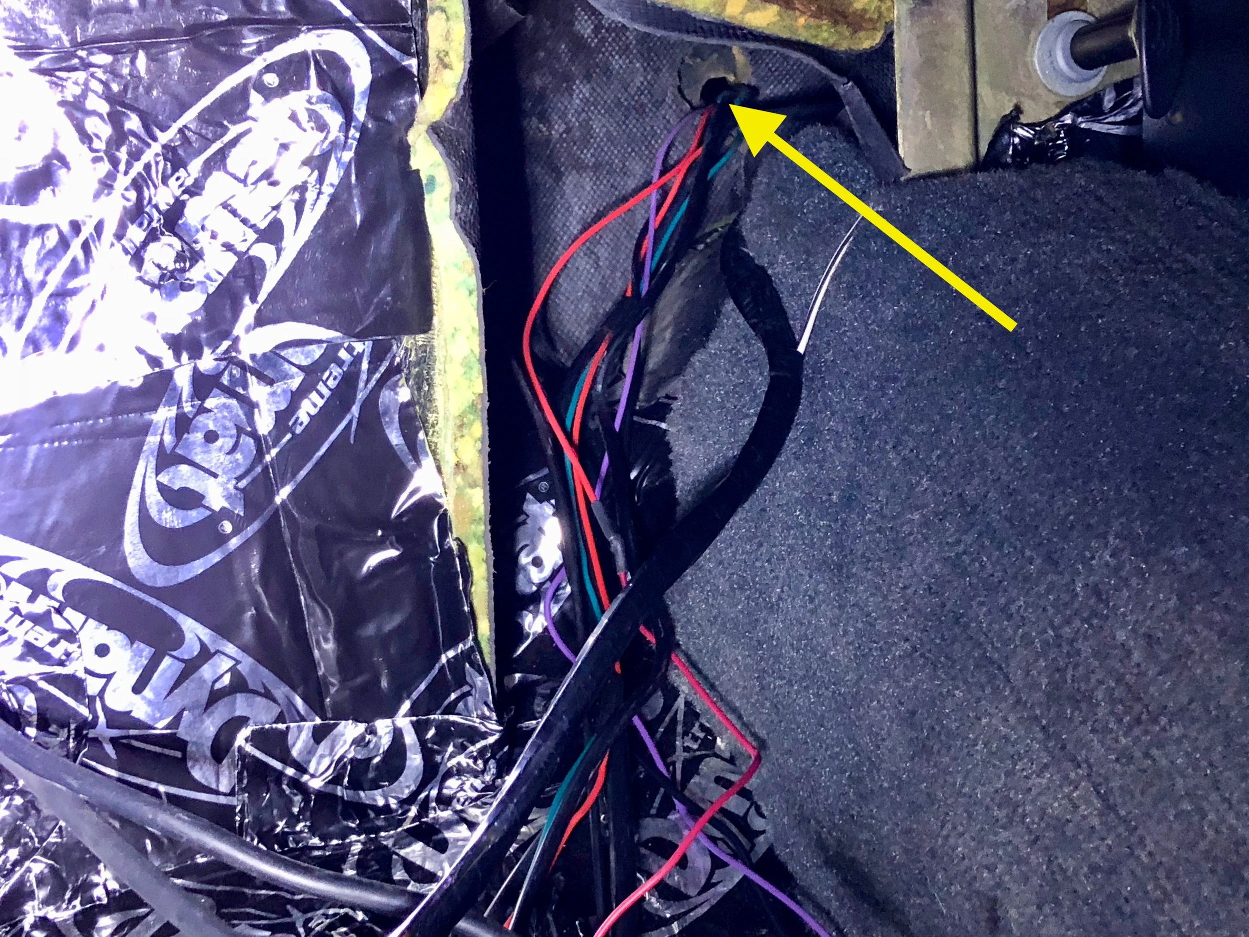 The wiring runs through a hole in the firewall behind the passenger side of the parcel shelf, then through a hole in fascia backing to the antenna.