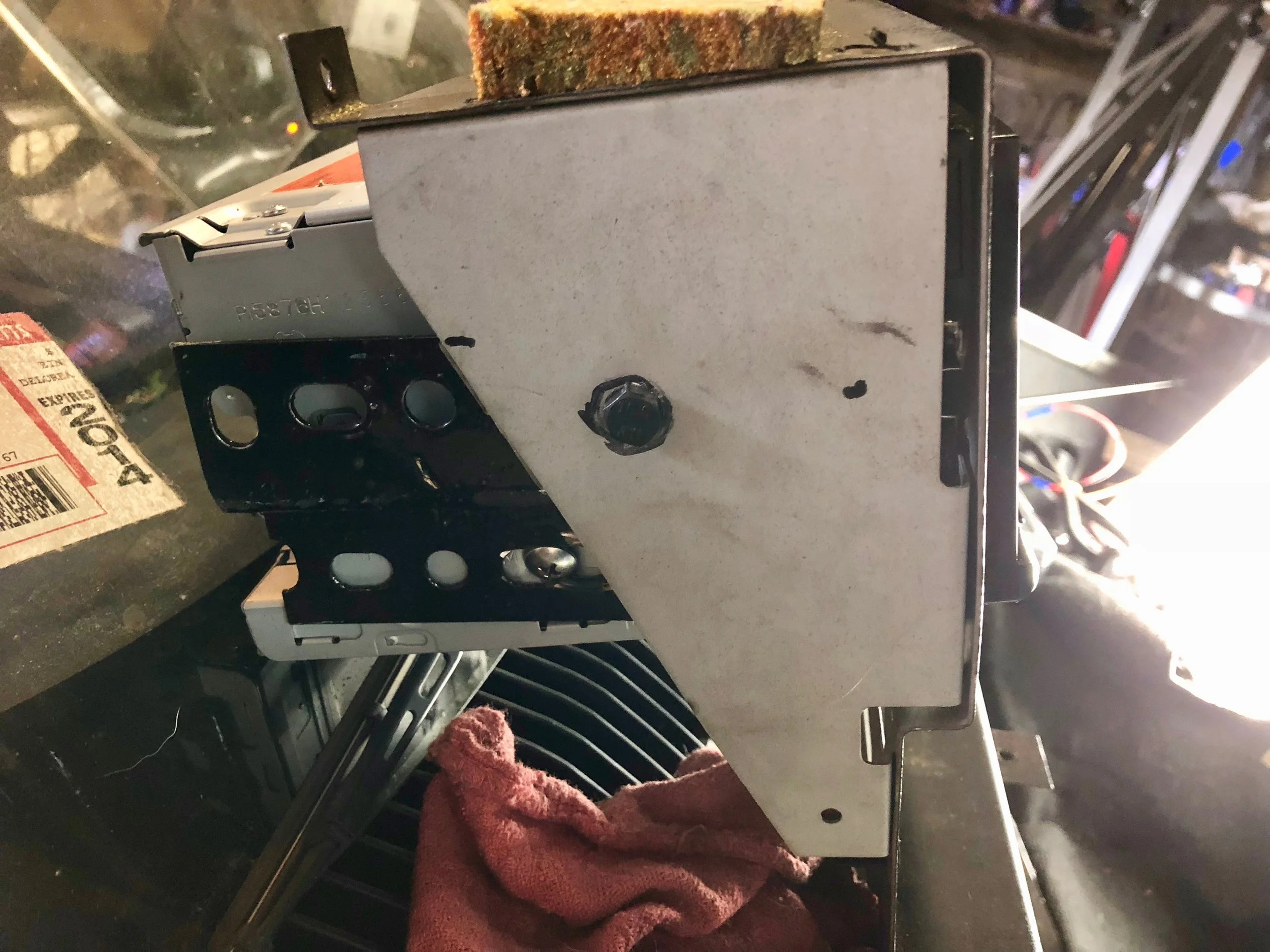A single bolt through each side holds the head unit and its brackets to the center stack.
