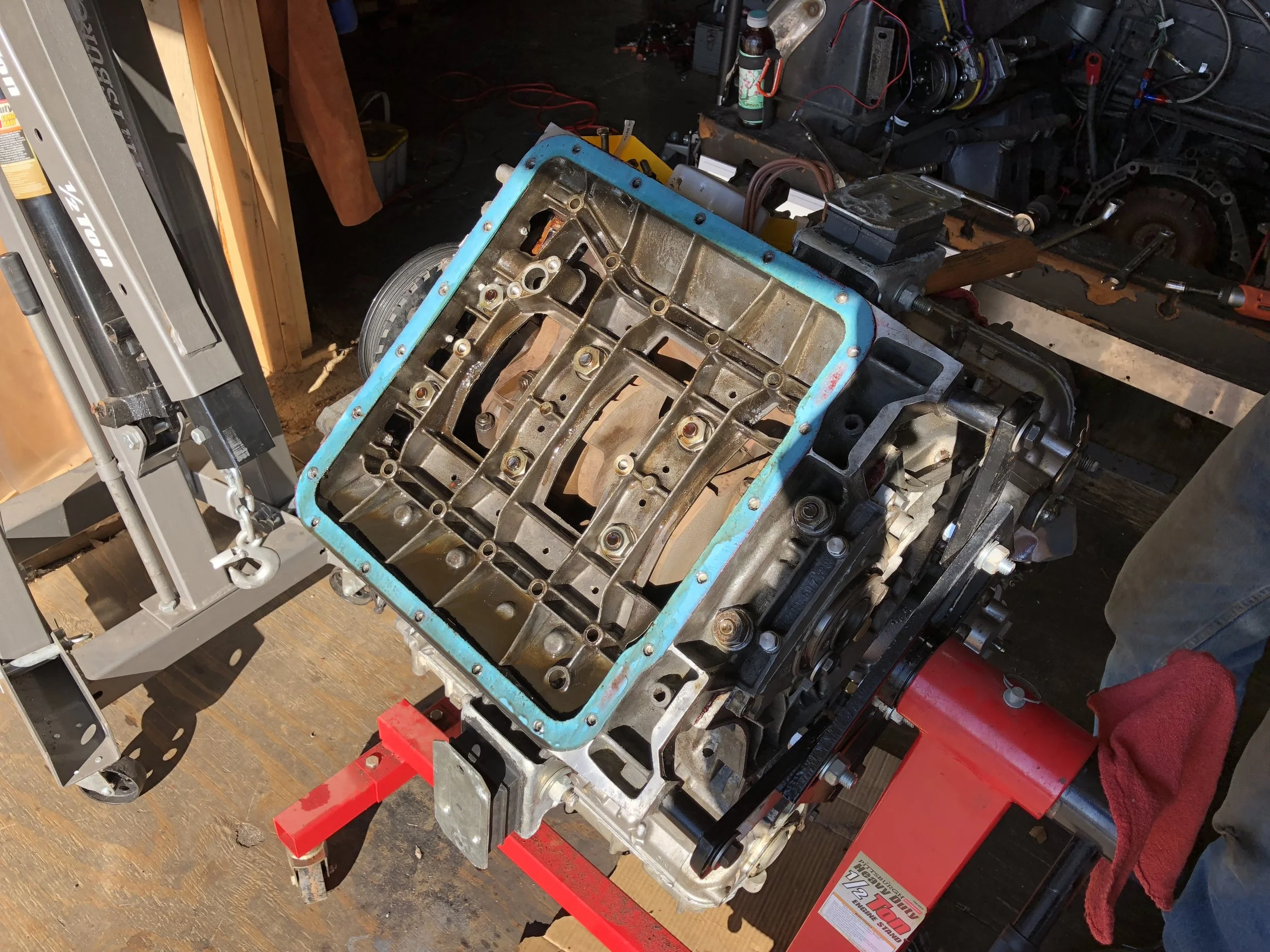 The oil pan, oil baffle and oil pickup removed, revealing the lower crankcase and the crank behind it.