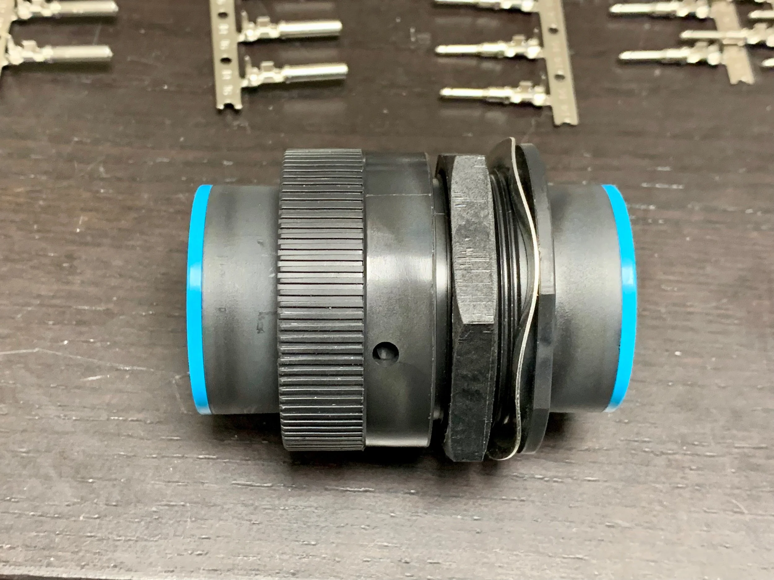 The coupled connector. The notched ring turns to lock the two pieces together. The nut and washer are used to lock the other end against the bulkhead.