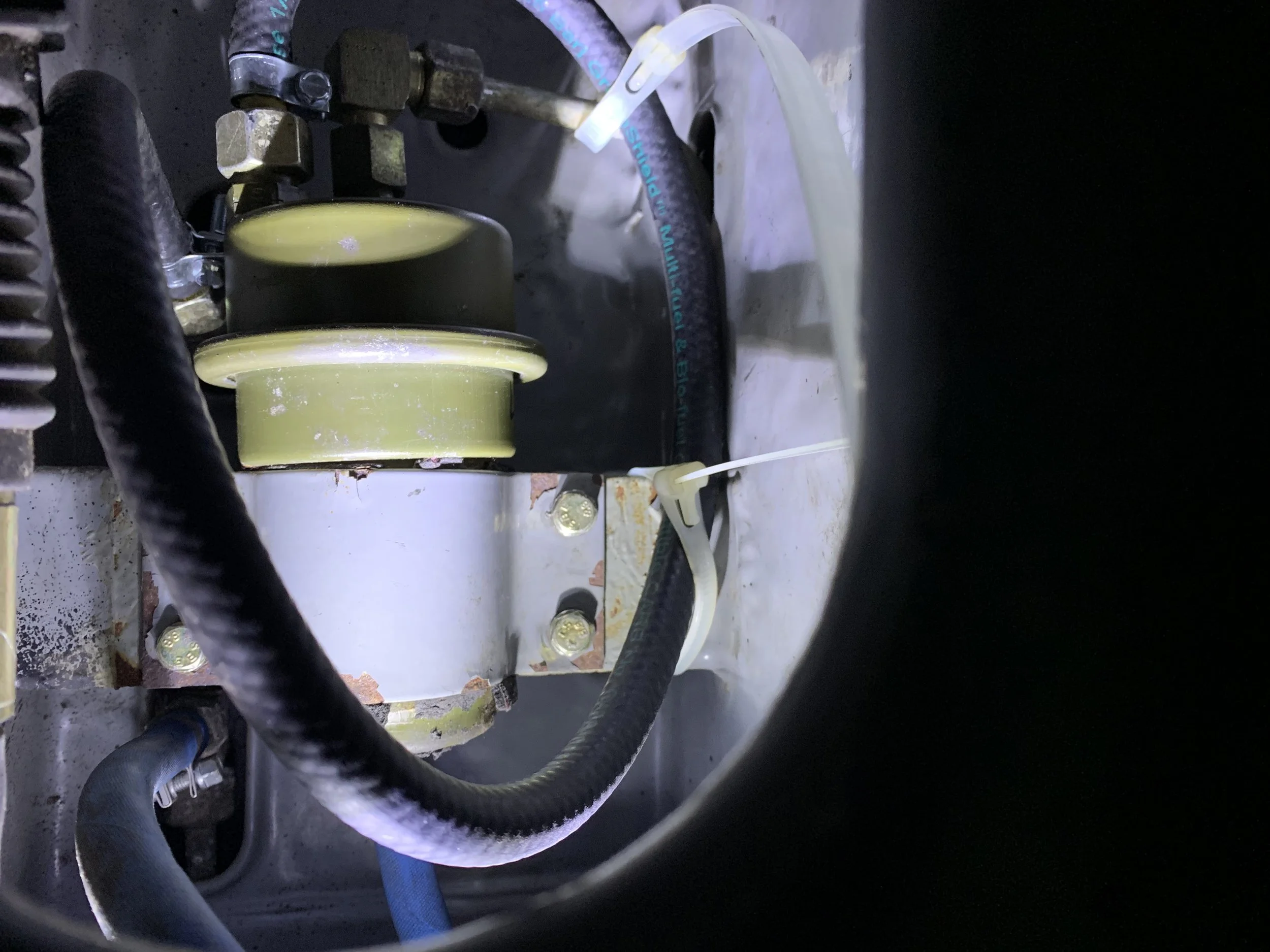 The hose pulled forwards and zip tied out of the way of the linkage.