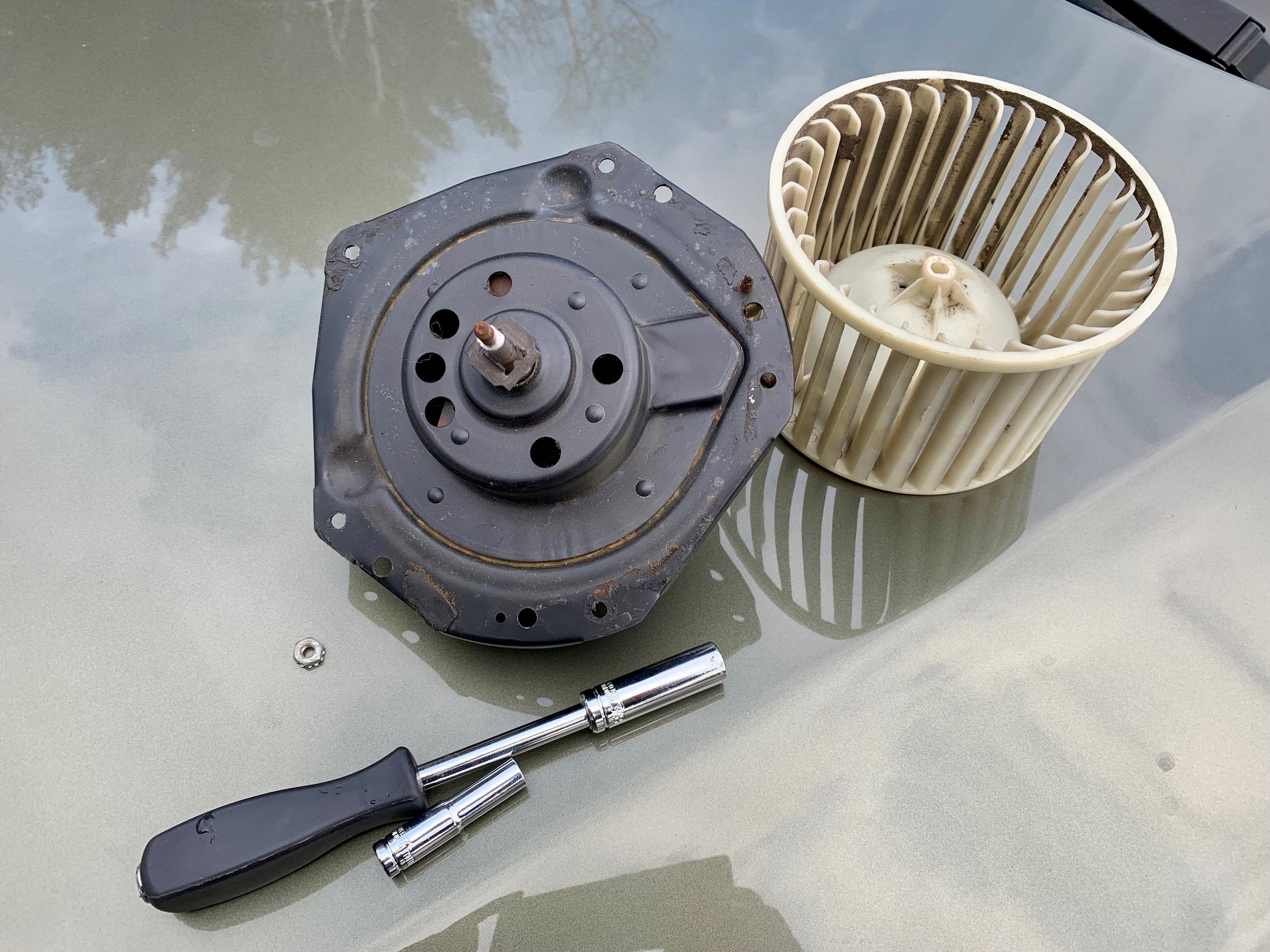 The old motor with its cage removed, and the two wrenches needed for the job.