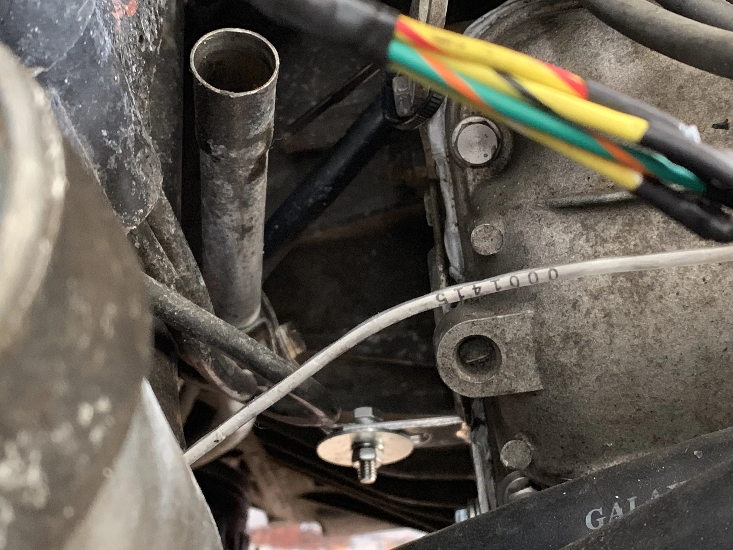 The dipstick tube mounted to the L bracket by means of a 10mm bolt, nut, and a large fender washer.