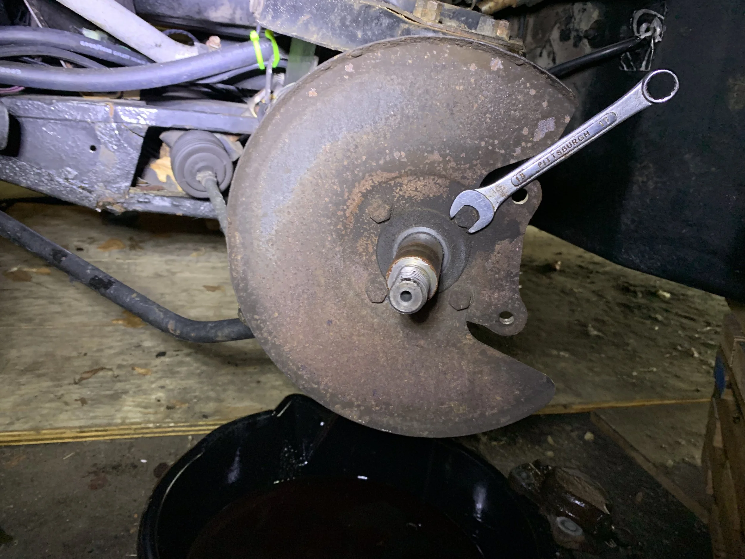 Using a 13mm wrench to remove the dust shield bolts.