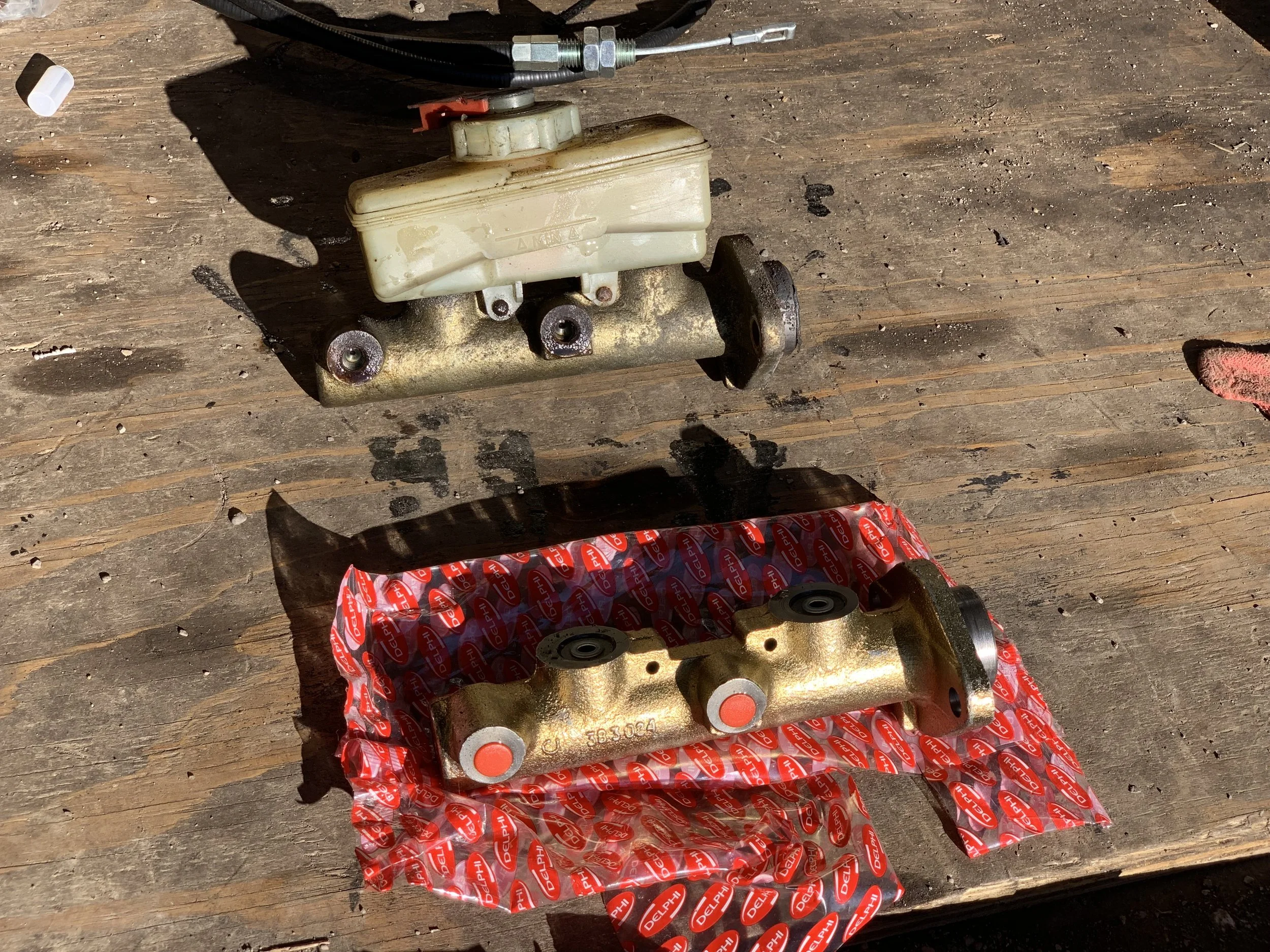 The old master with the reservoir still attached (top), and the new reservoir with its safety plugs still in place (bottom).