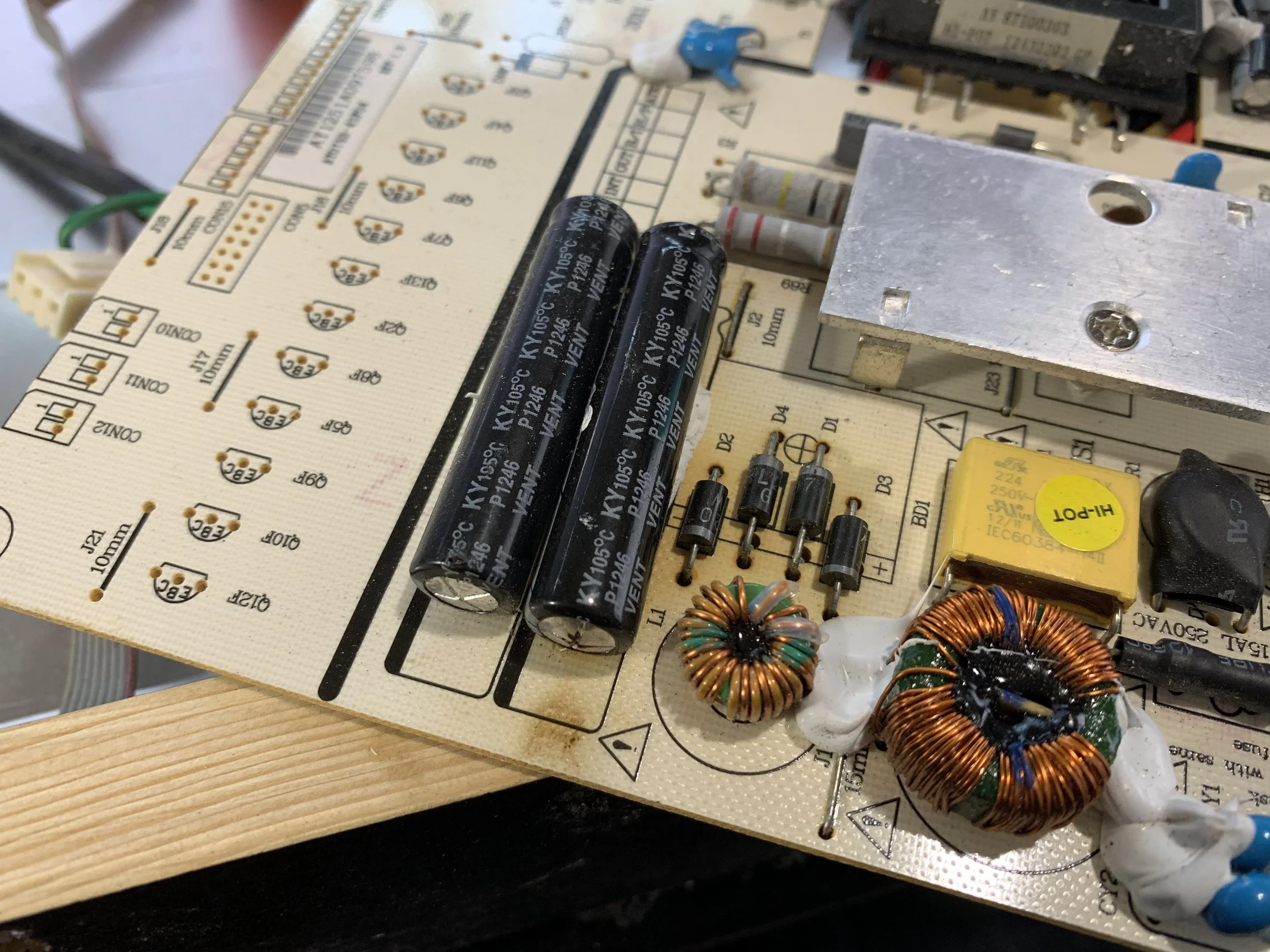 The rightmost large capacitor has a bulge and burned out end. The four diodes next to it also read as bad when tested with a multimeter.