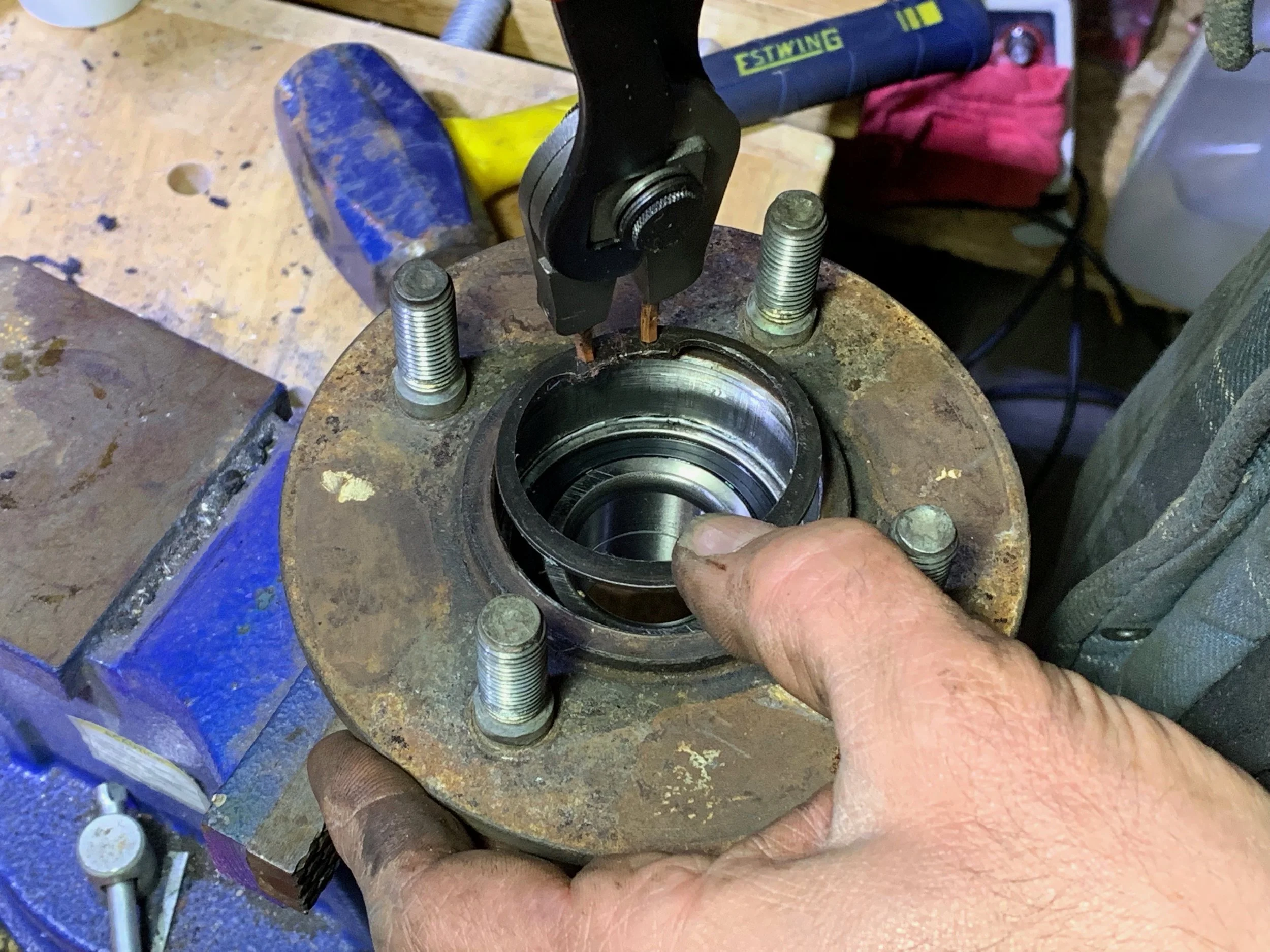 Installing the retaining ring back into the hub to keep the baring in place.