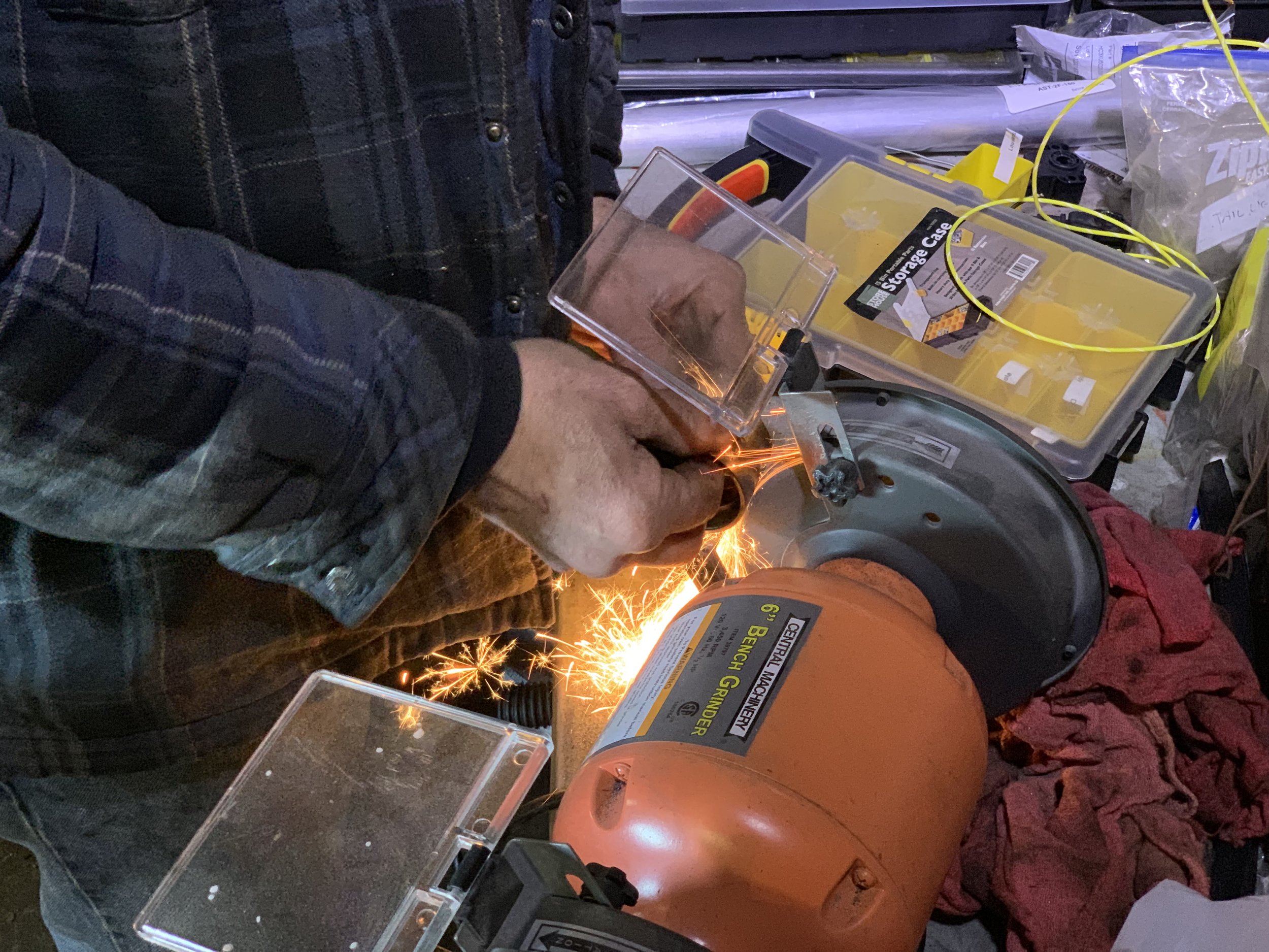 Using a bench grinder to reduce the size of an old bearing so that ti can be used to press the new bearing in.