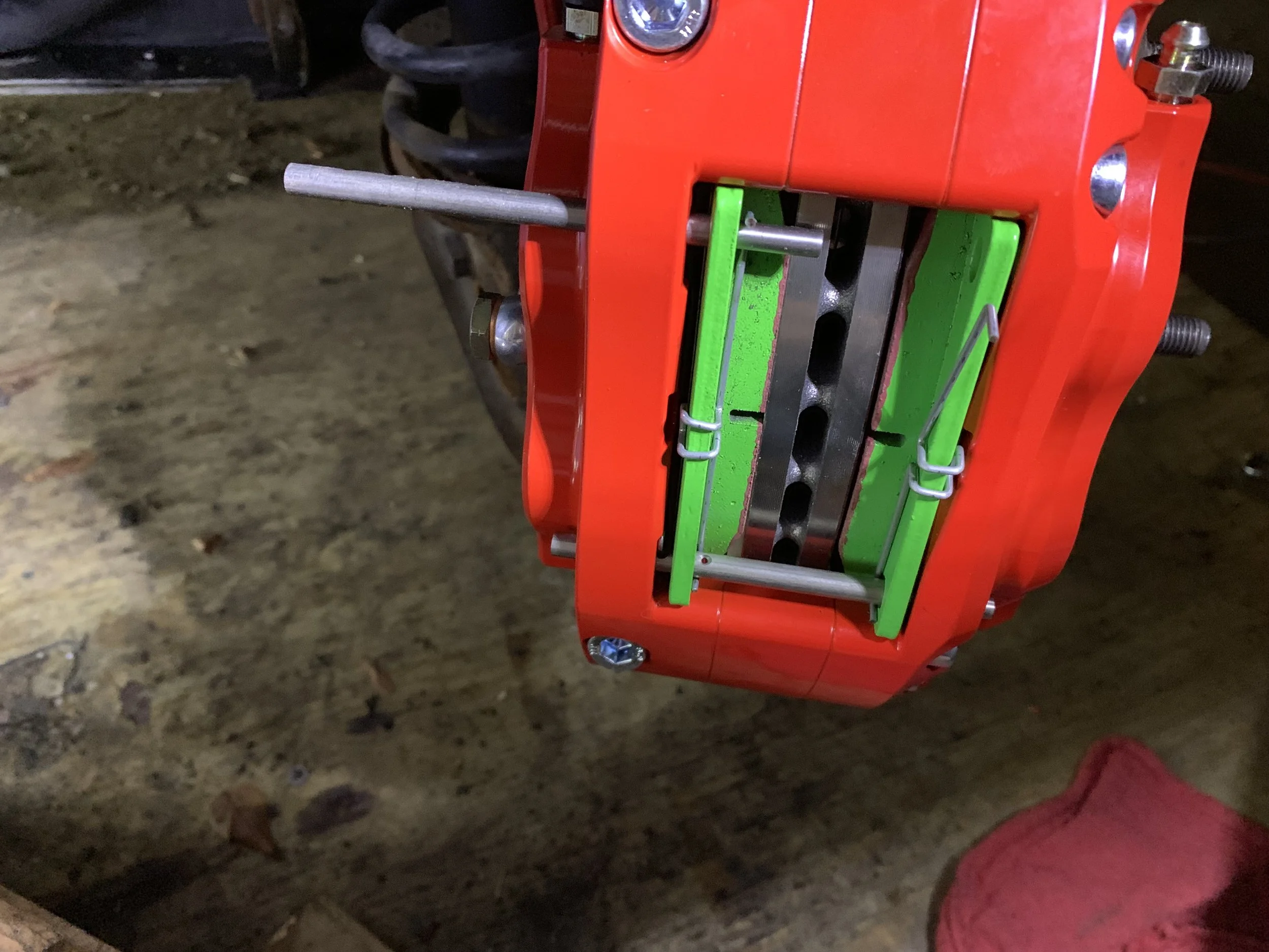 The second pin partially installed. The anti-rattle spring is already attached for clarity, but normally it would be installed after the pin is fully inserted.