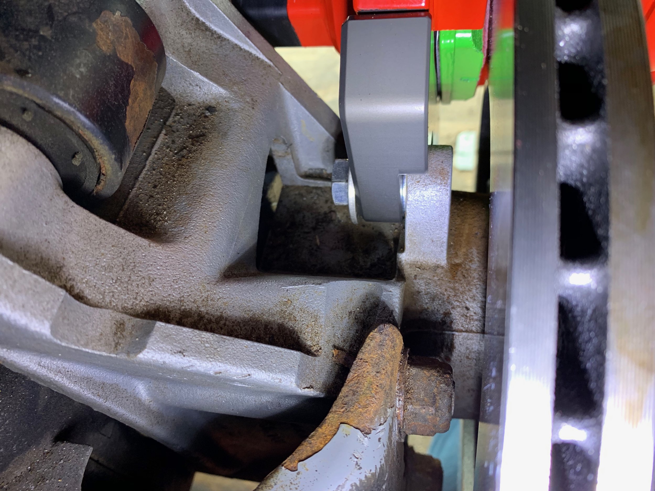 The mount bolted onto the hub carrier behind the new rotor.
