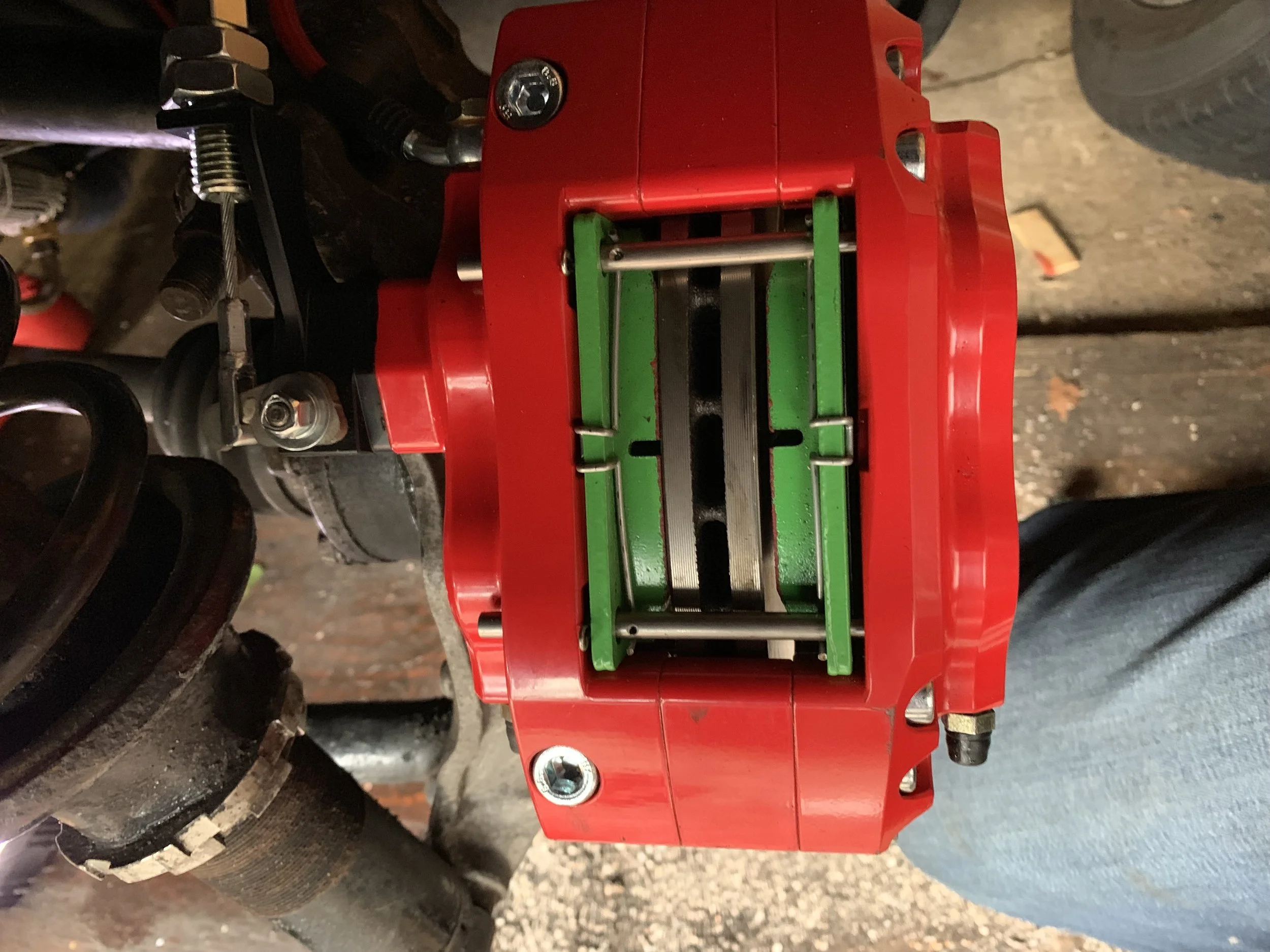 What happens if you accidentally swap the washers and spacers. Notice how one of the pads (green) is pushing against the rotor (silver) (left) while there’s a gap on the other pad (right).