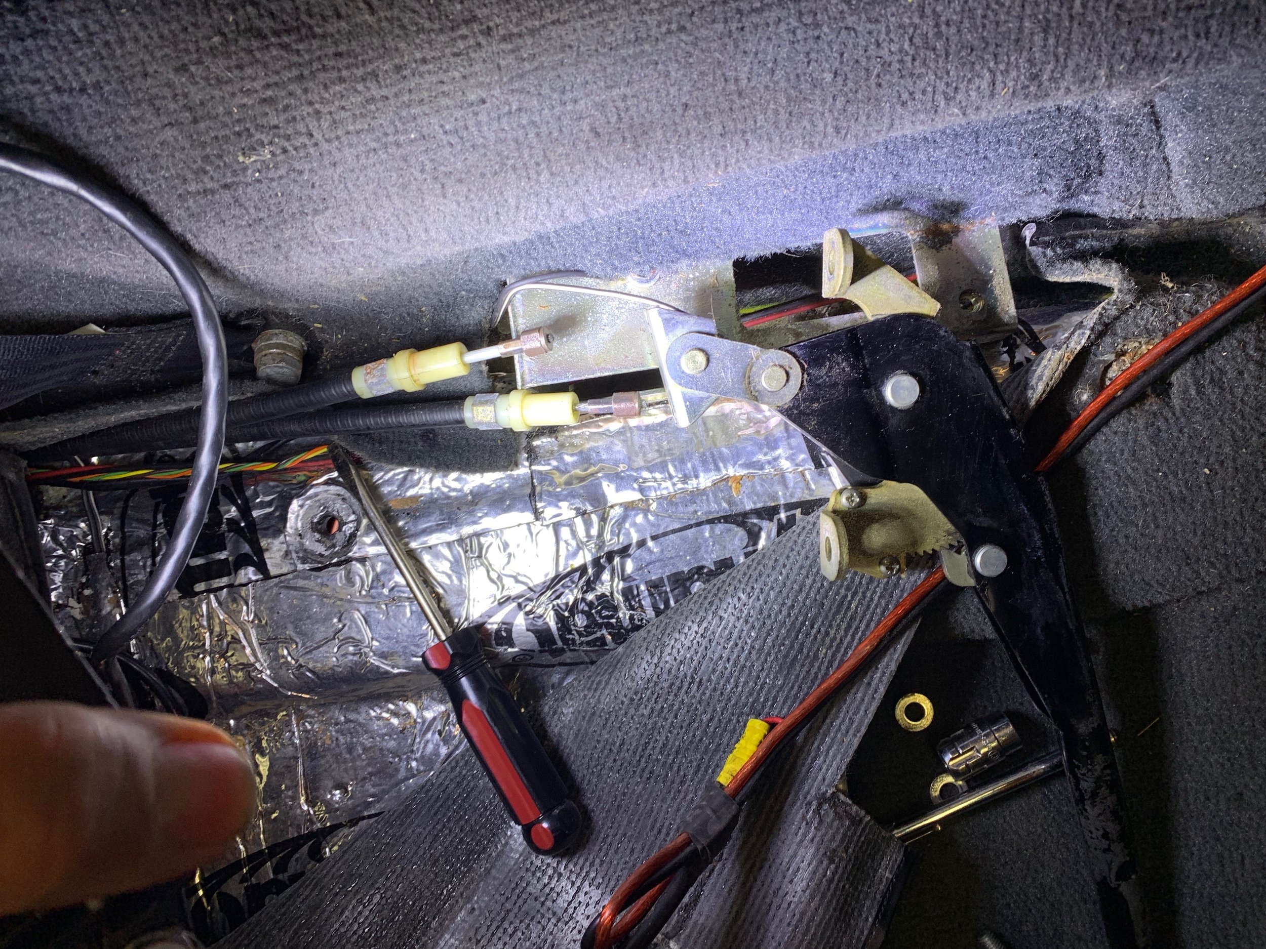 I also removed the brake lever, but this doesn’t actually help, other than giving a better understanding of how the mechanism works. The ends of the cables can be seen here as well. They slip into slotted holes the silver bracket at the base of the lever.