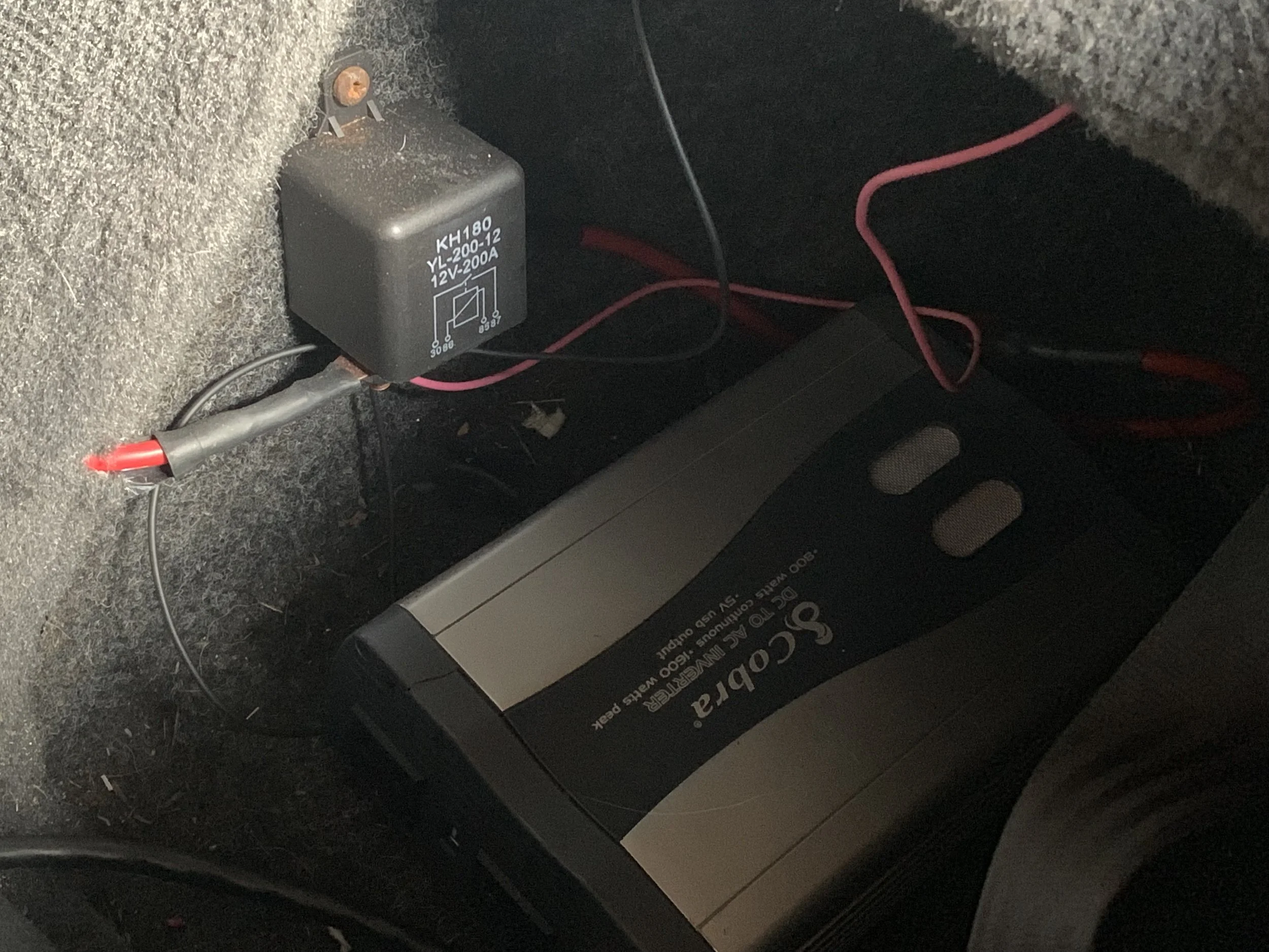 The 200A relay screwed into the lock box behind the driver’s seat. One of the large red wires goes directly to the battery, while the other goes to the inverter. The smaller wires run to an ignition-switched fuse box behind the passenger seat. The inverter’s ground goes directly to the battery.