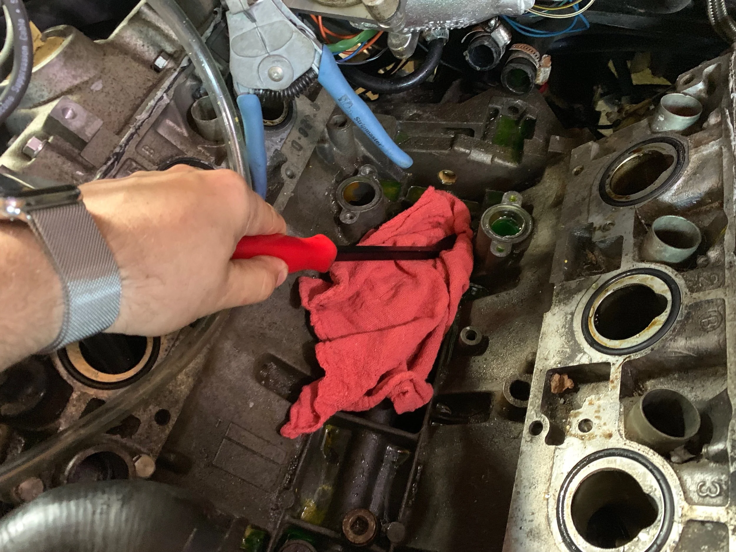 Using shop rags to clean out the rest of the “V”, pressing them into corners with a pry bar.