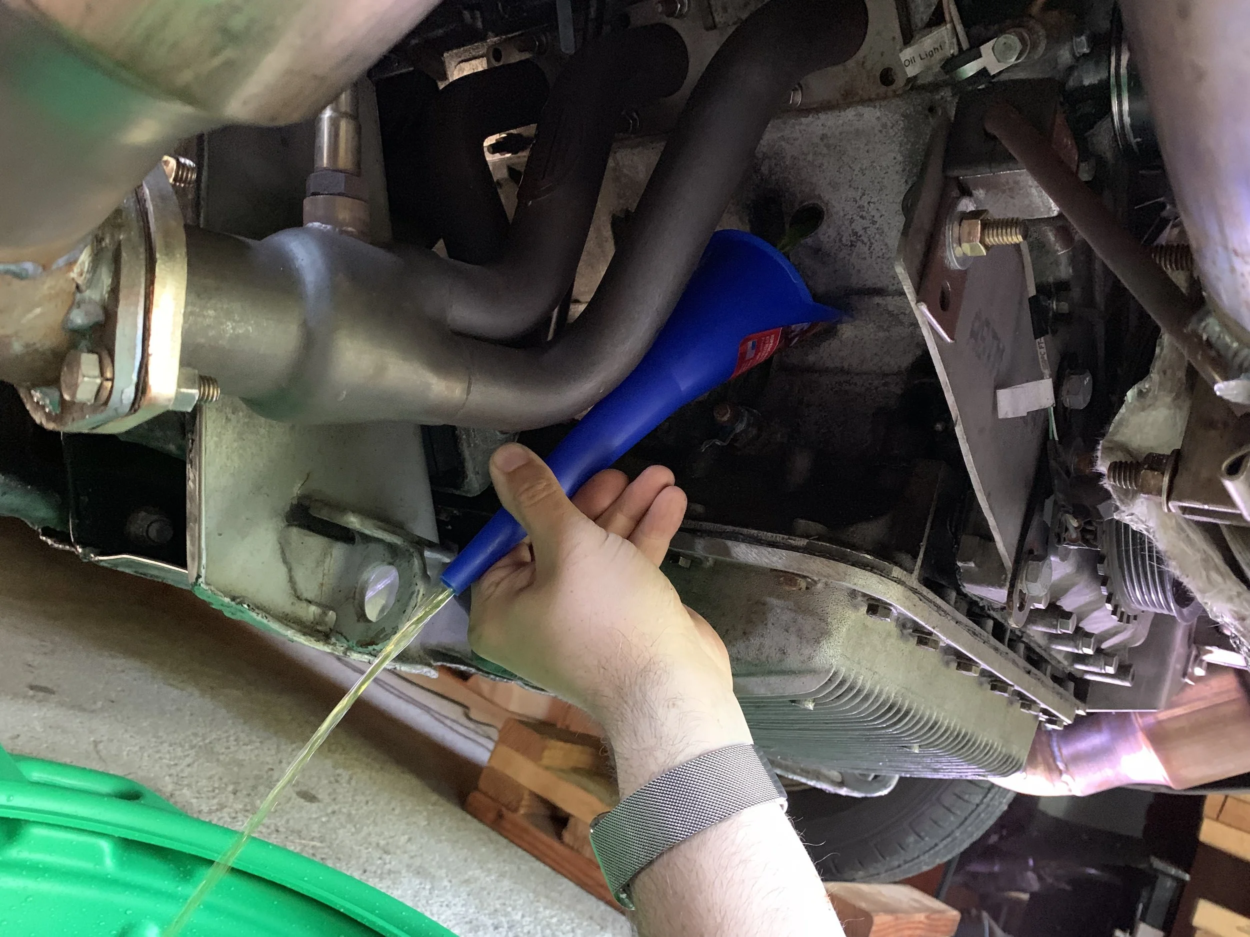 Draining coolant from the first drain plug.