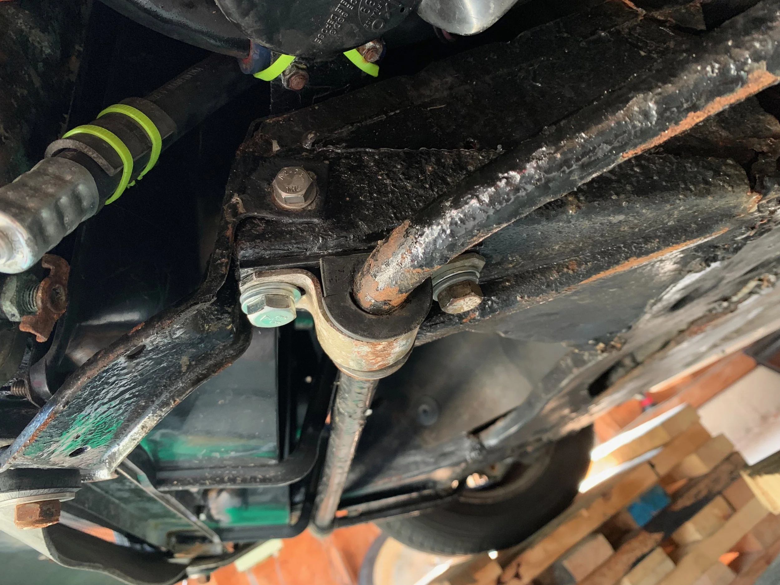 A new M10 bolt inside the newly repaired hole with the restored bracket.