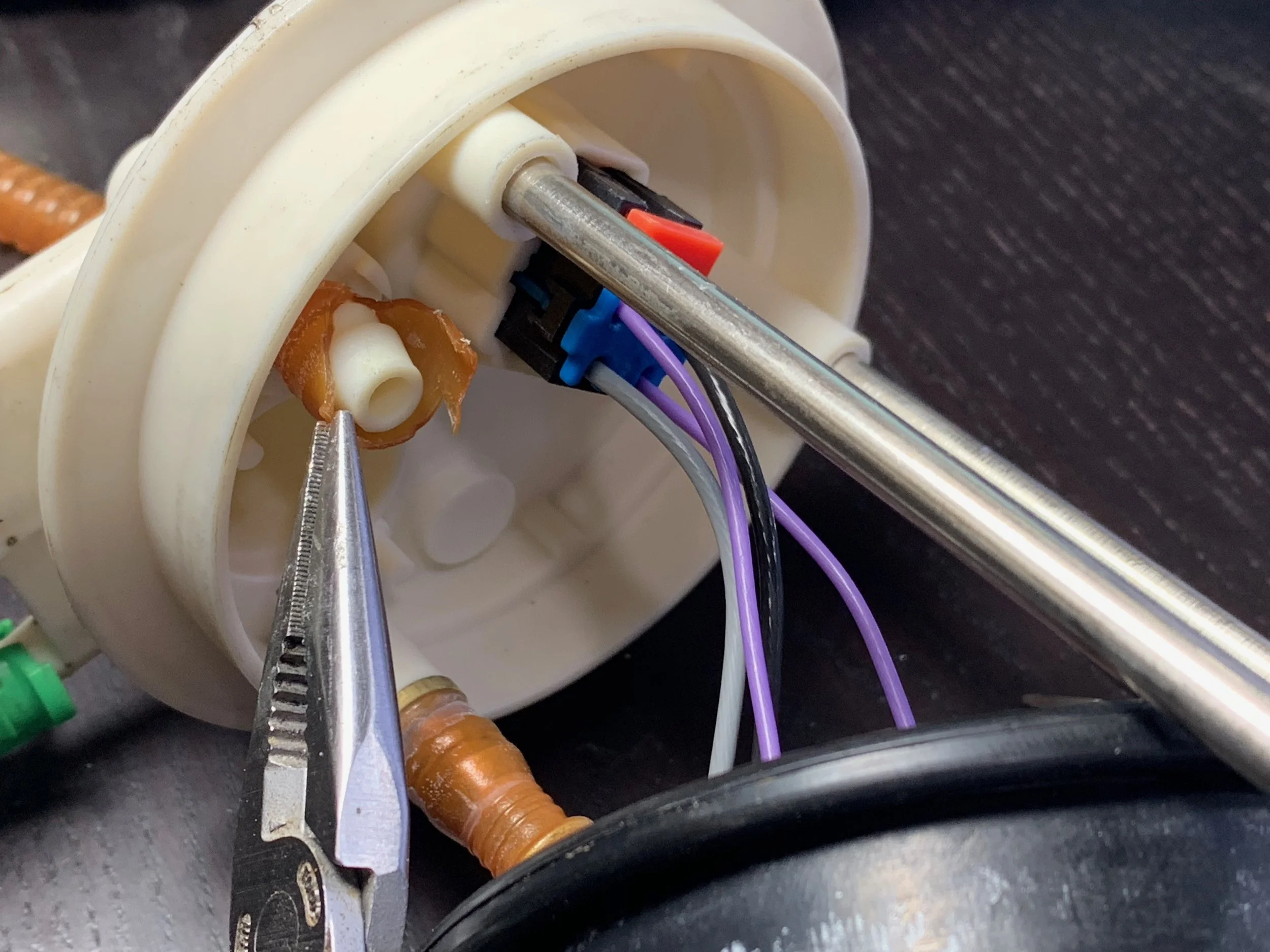Removing the cut fuel line from the cap.