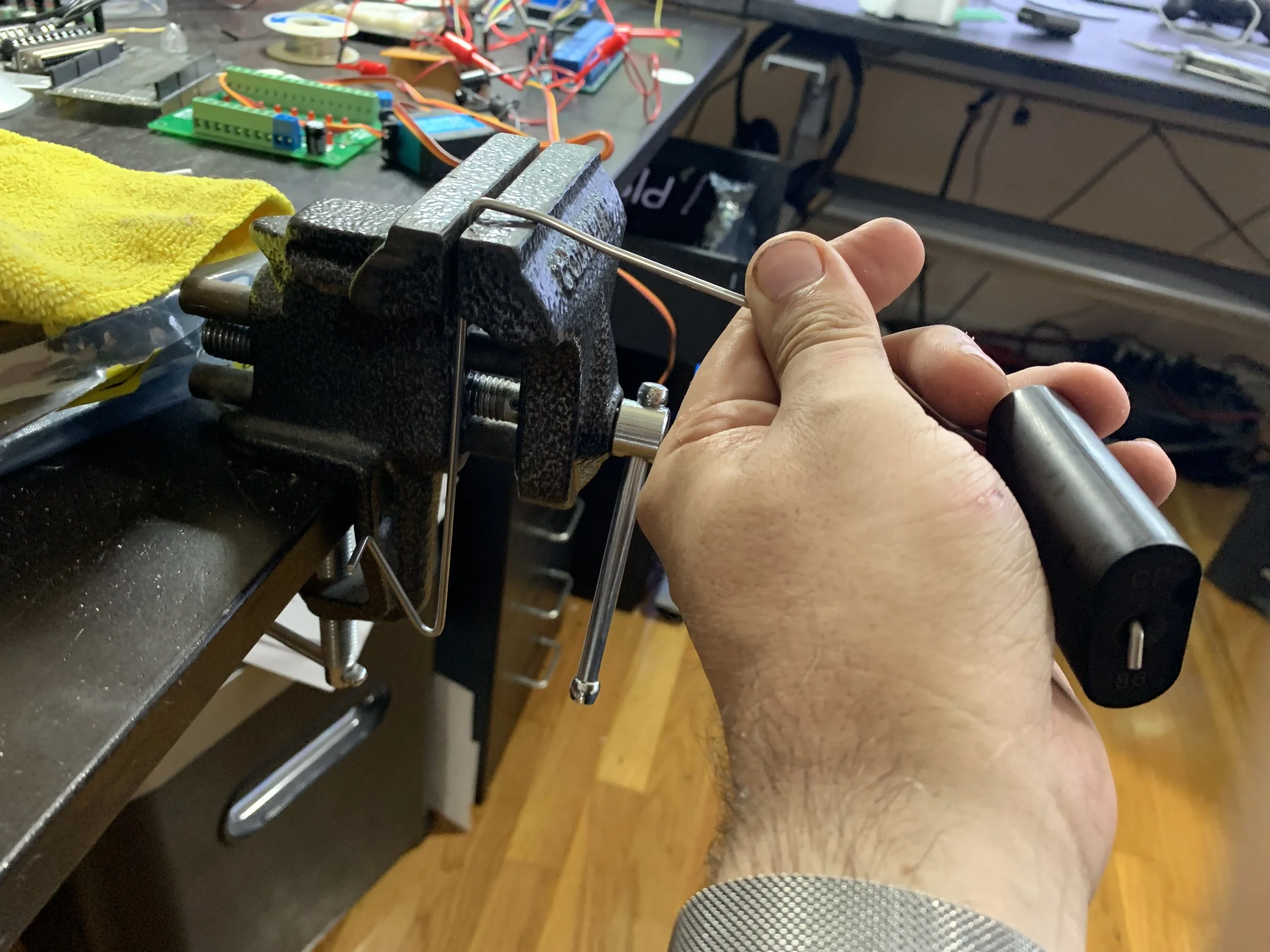 Using a vice to bend the arm. I also used pliers to squeeze sharp curve further (visible below the vice jaws), and bent the again near the joint where my hand is so that it sat properly at the bottom of the tank.