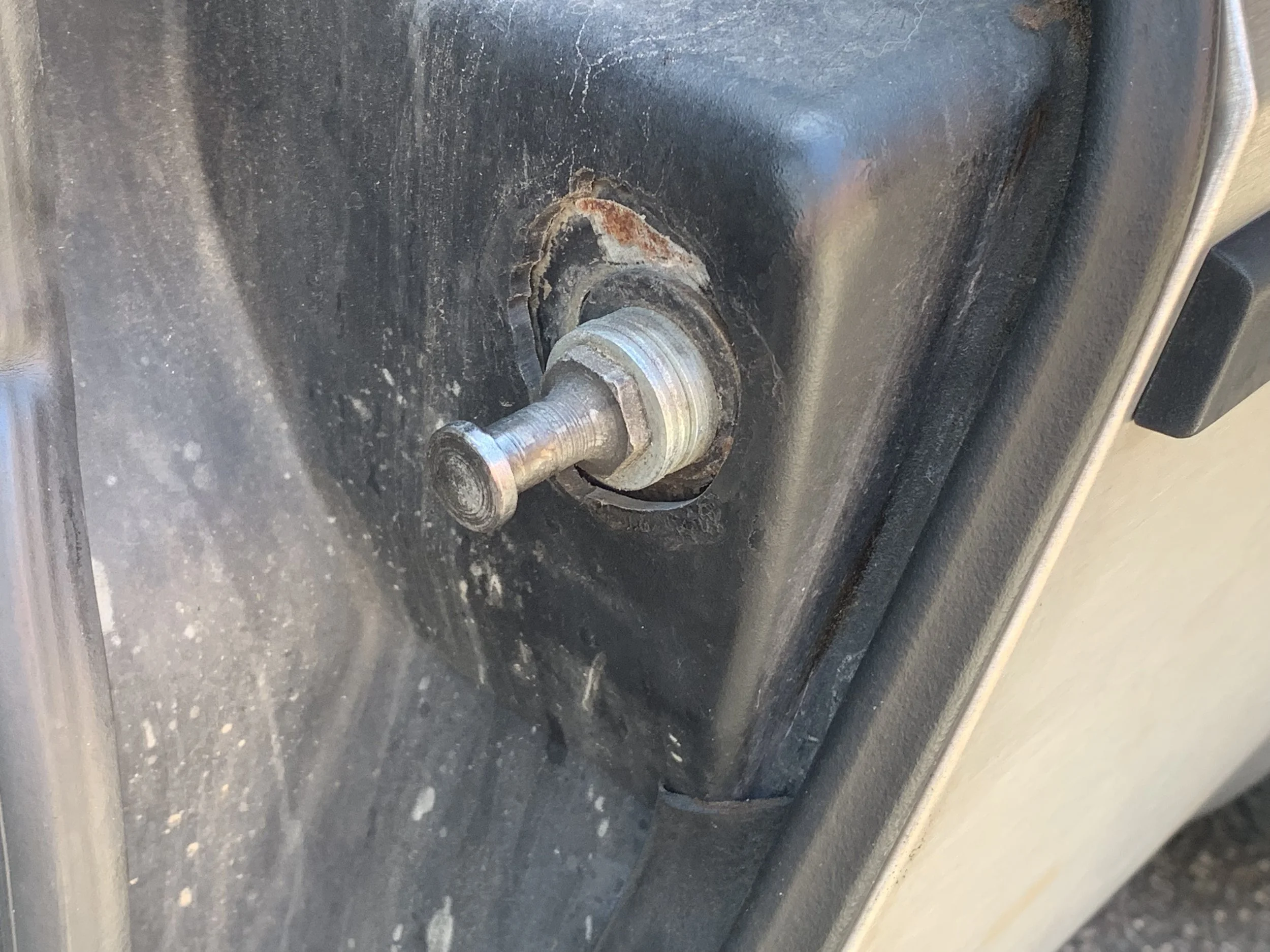 The stack of washers on my front passenger striker pin, and the recess in the fiberglass to allow for more adjustment.
