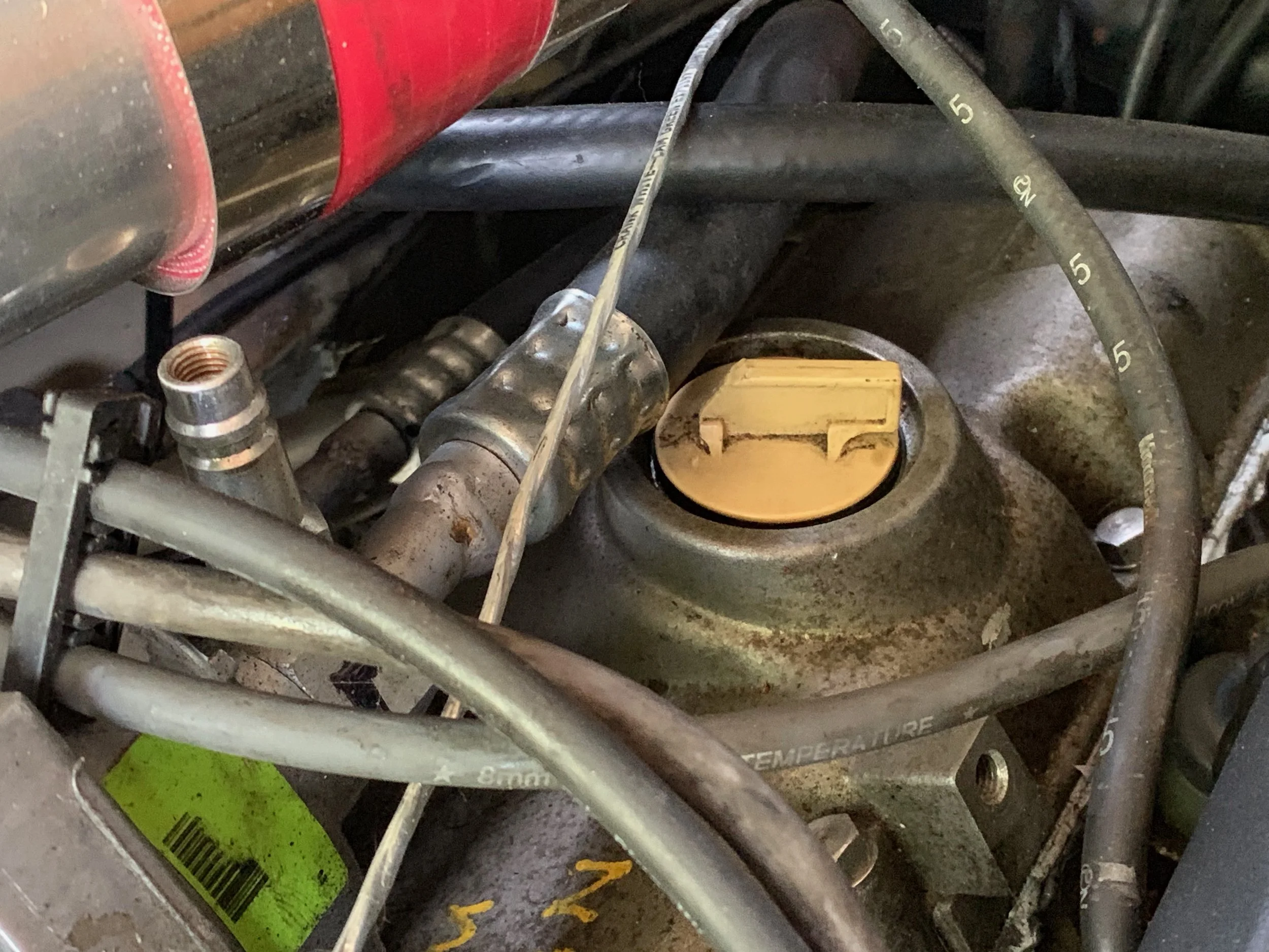 The cut cap in the open position. The notched out handle allows it to clear the A/C line.
