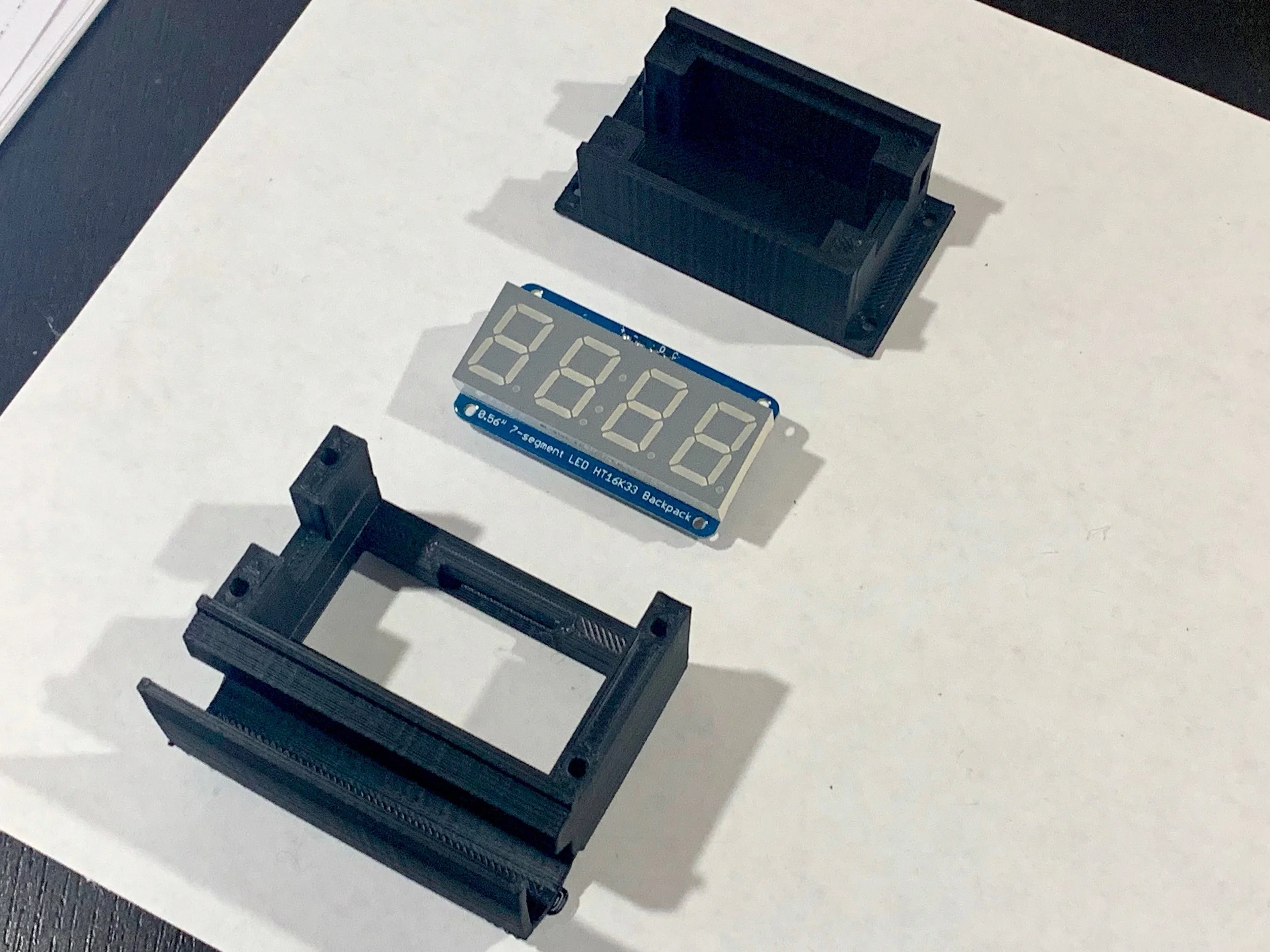 The two part ABS case and the Adafruit seven segment LED backpack that is sandwiched between the ABS halves.