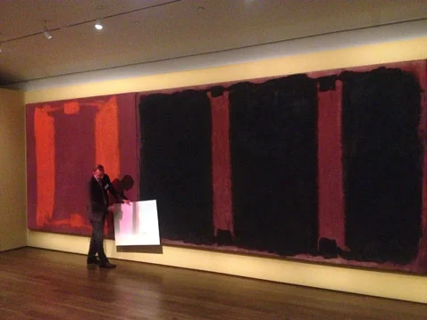 A conservator demonstrating the effect of the projection with a poster board
