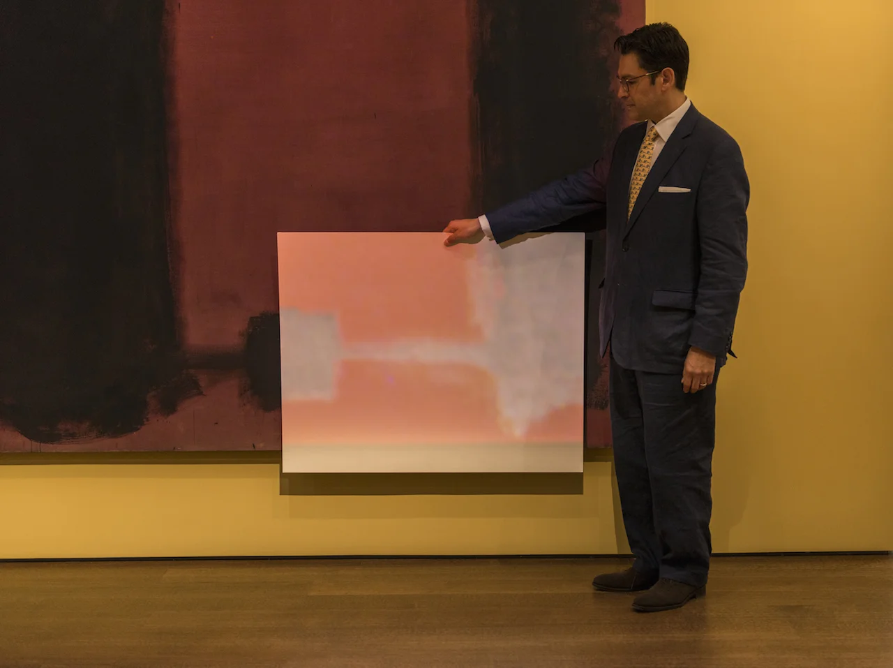 A conservator demonstrating the effect of the projection with a poster board