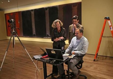 Members of the curatorial and conservation team test the system