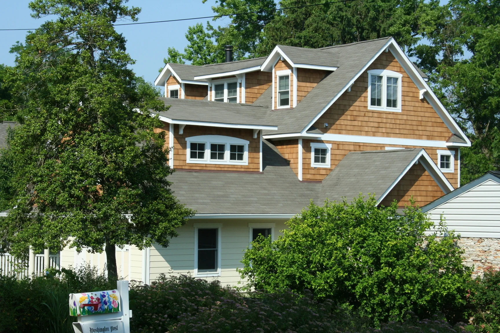 After: taken from approximately the same point as the previous photo, the new Music Room gabled roof blends into the new front-facing garage roof.