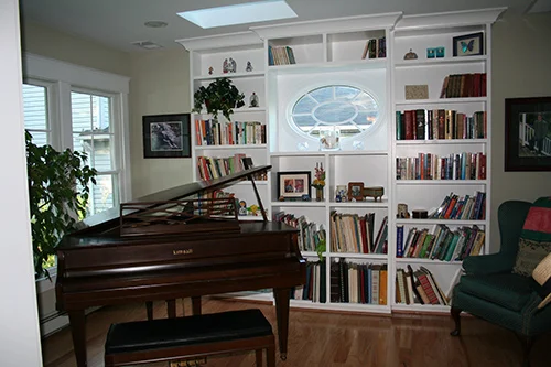 This sweet elliptical window is visible from the stair hall. Windows to the left of the piano look to the water.