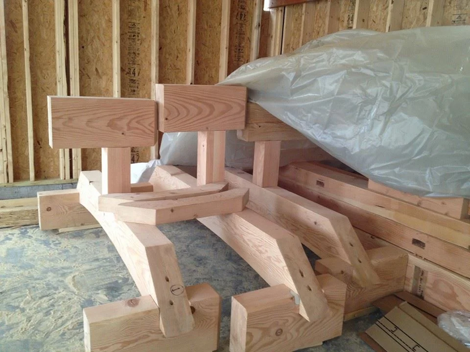 Timber-framed homes are expensive, but these clients wanted to duplicate this look on a budget. I designed these timber accents for a few of the house gables. Michael Taylor built them in his shop, along with those load-bearing brackets you saw on the tower, for the balcony. Here are their halves, ready for hanging.