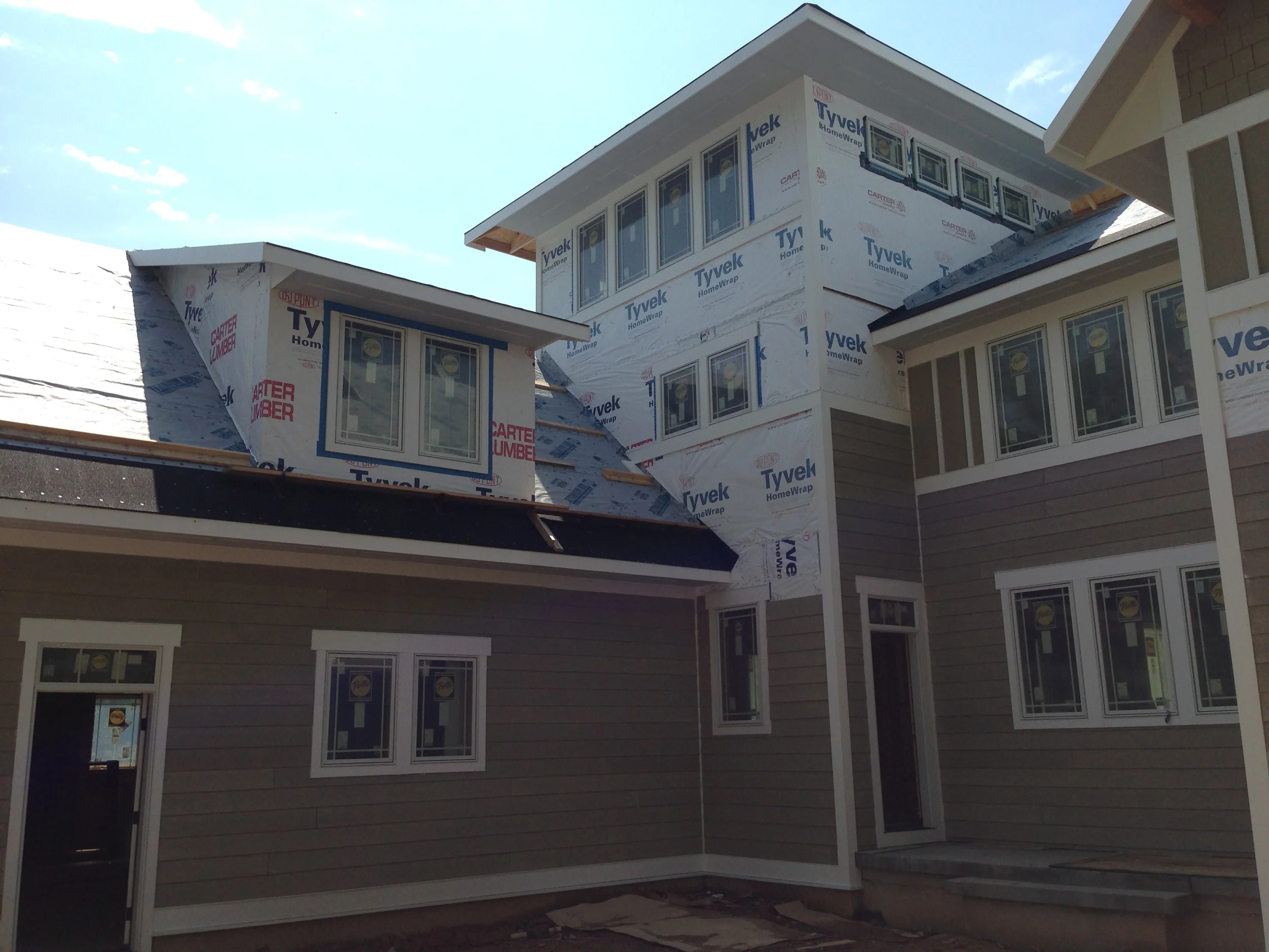  The fiber-cement siding is being hung.&nbsp; Note:&nbsp; this is only a primed material, and will be painted later. 