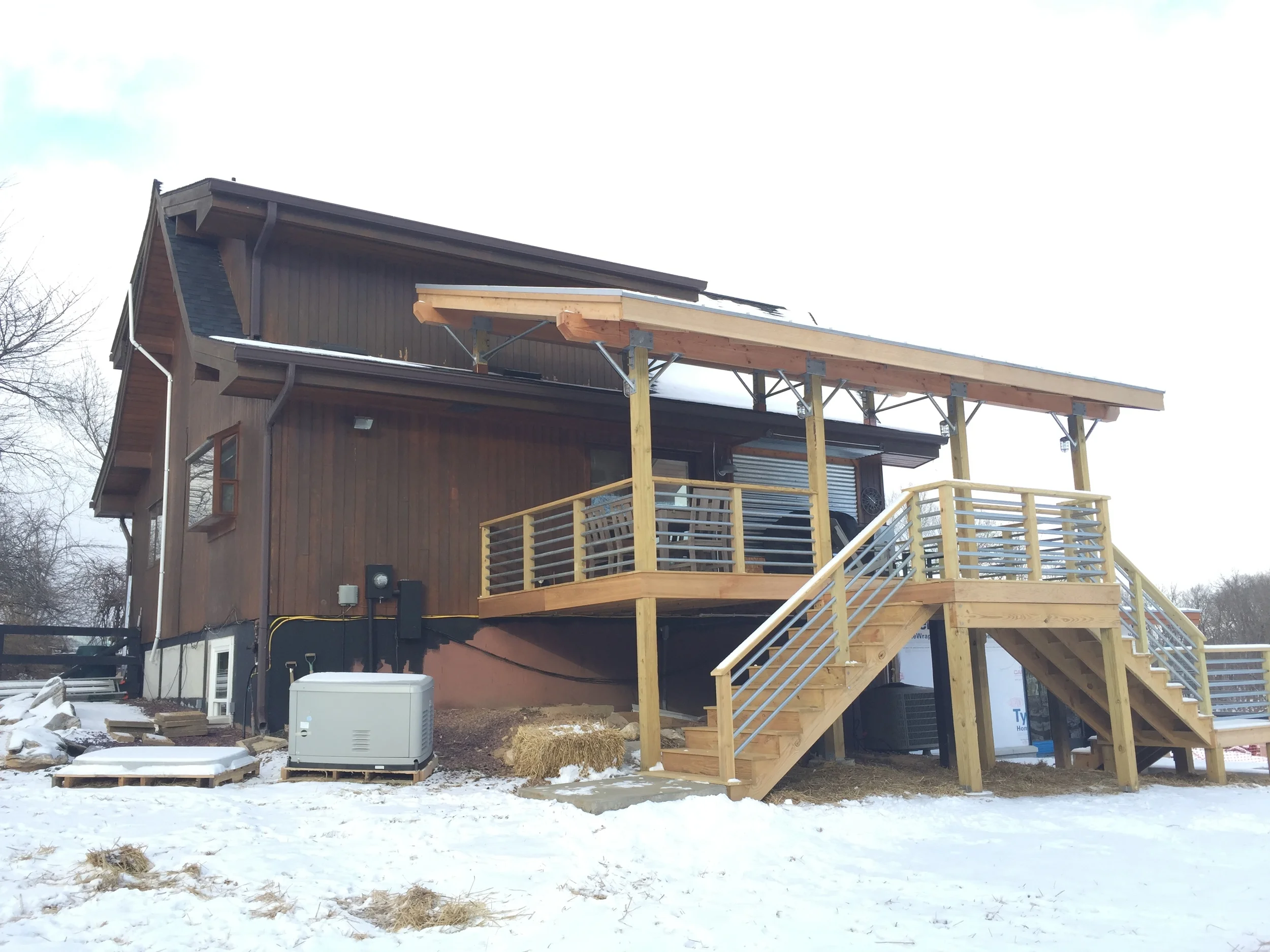 DURING: The existing and expanded decks continue to have horizontal metal rails; new structural brackets were designed to be exposed and compliment the rails.