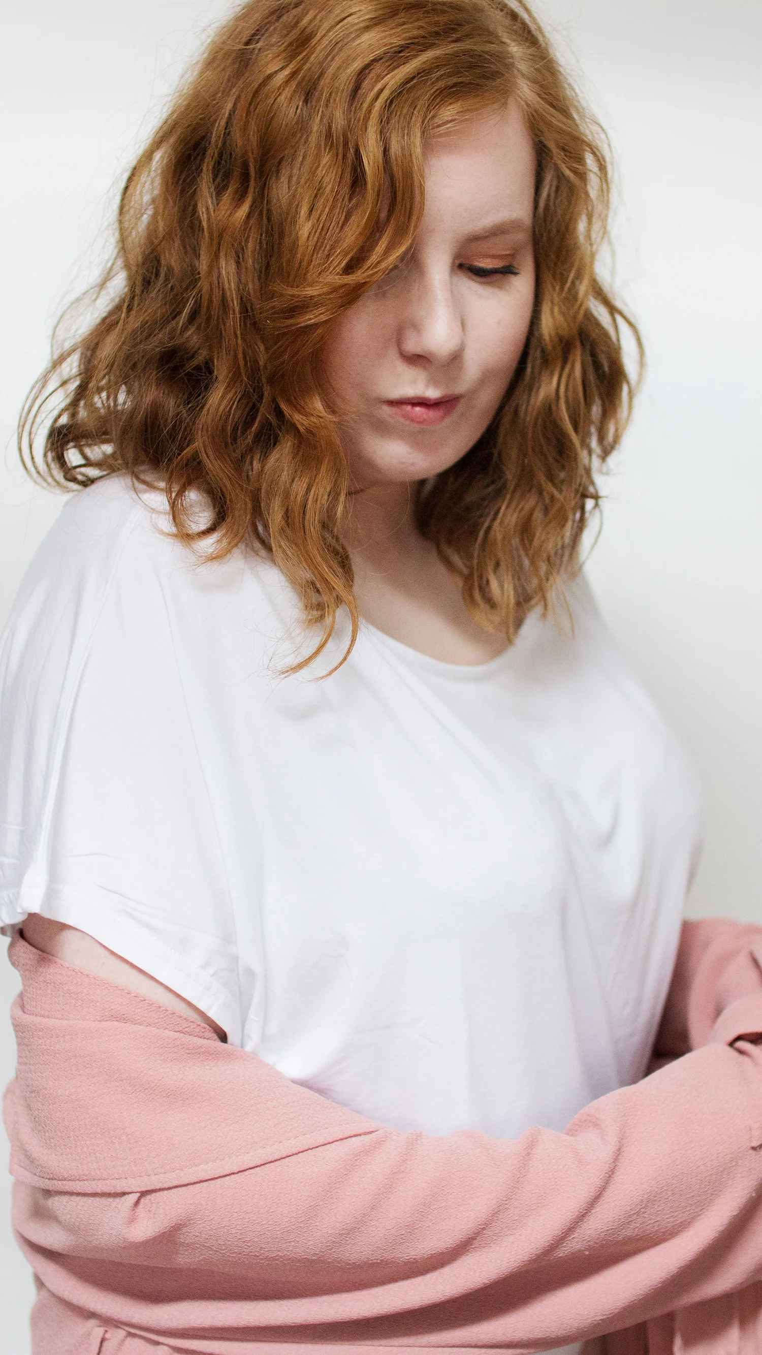 Woman in white tee and pink blazer