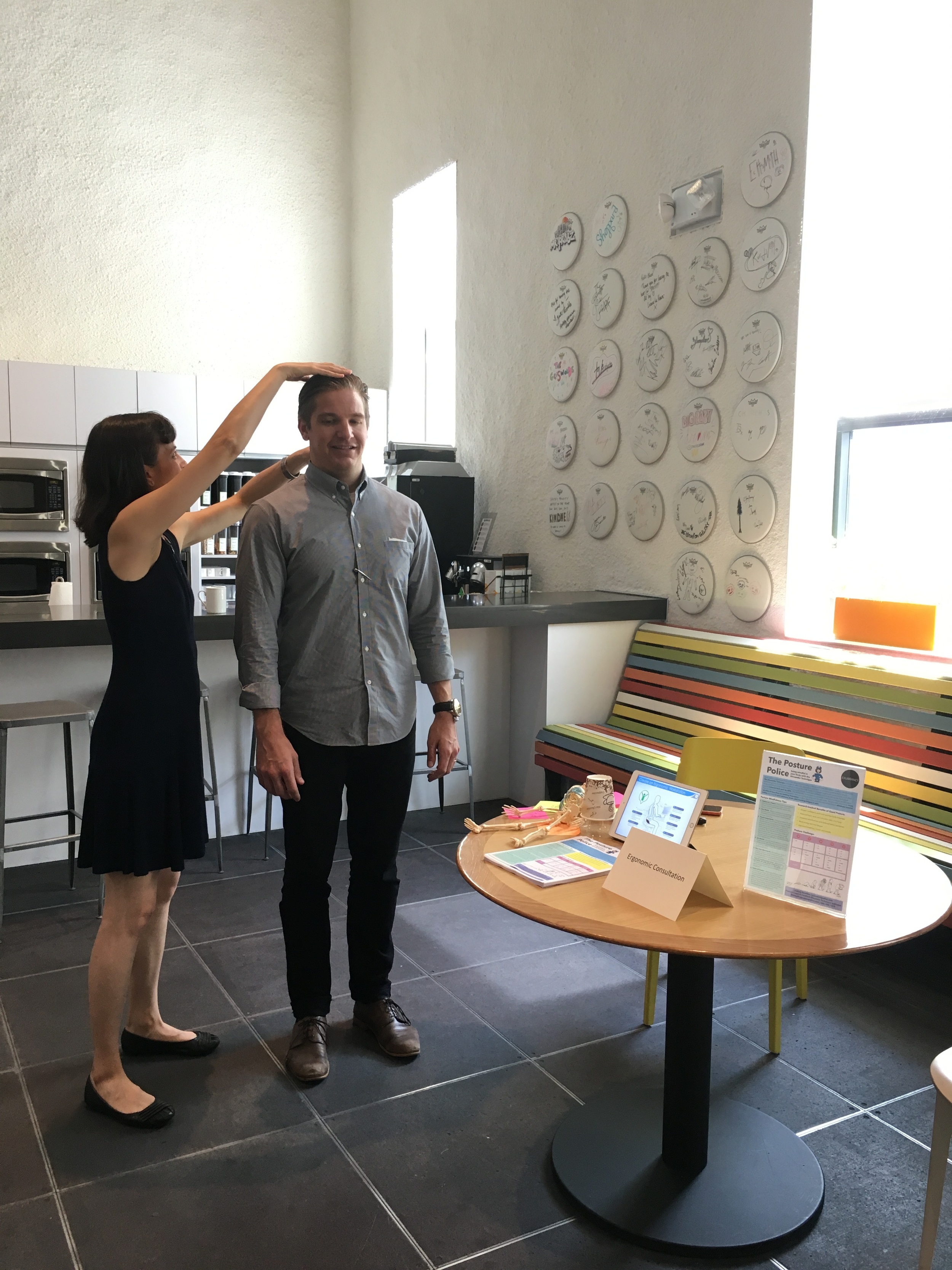 demo table at spotify - Lindsay offering posture tips to an employee