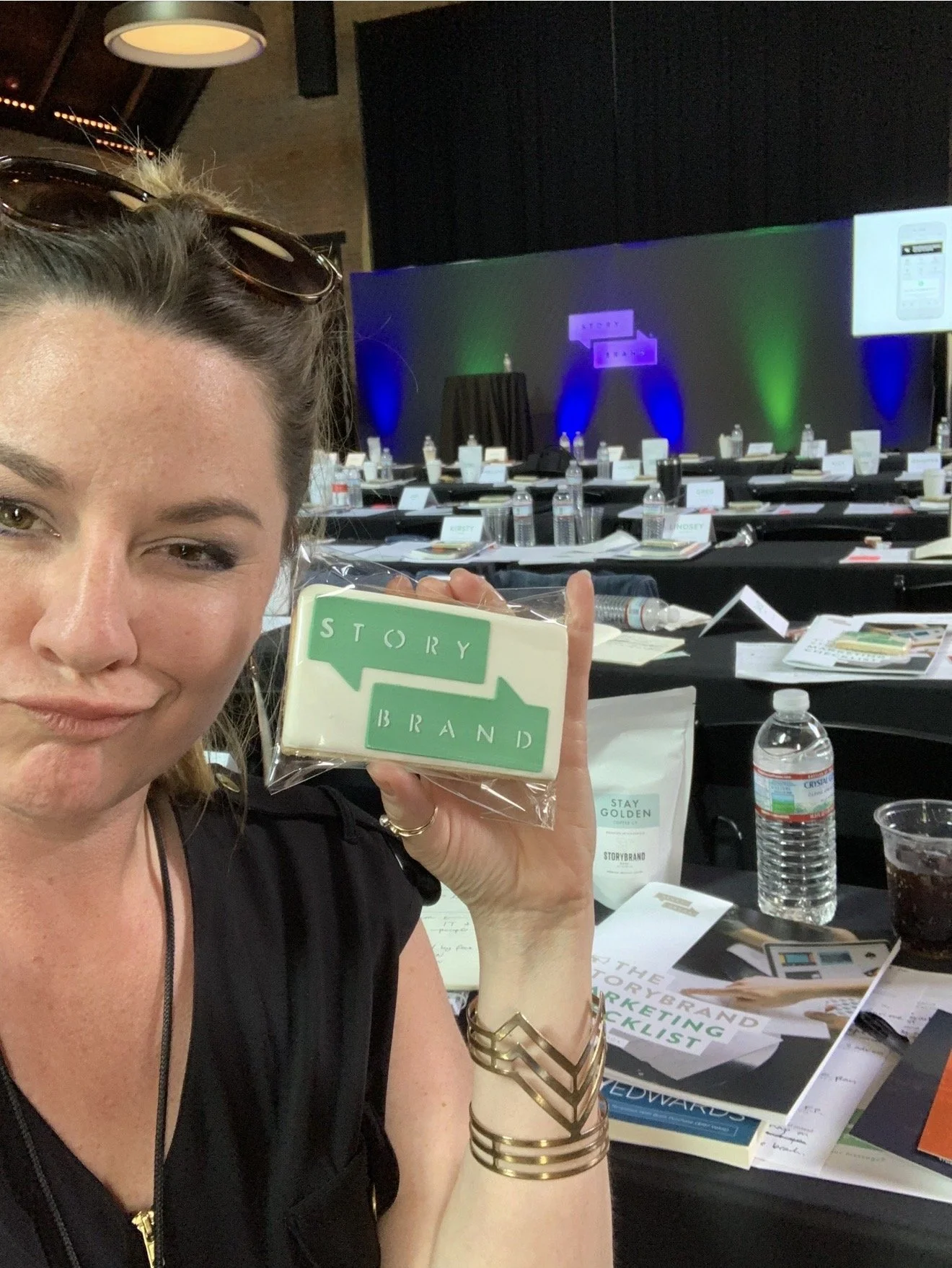 Selfie of Shea at StoryBrand Conference holding a cookie with a logo