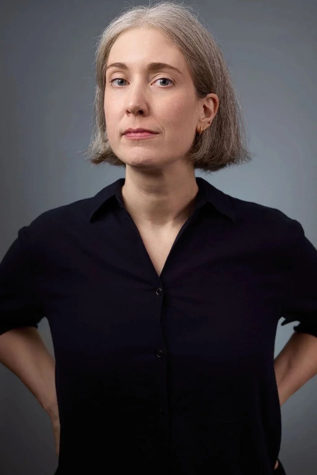 A portrait of a white woman in a blue button down shirt.